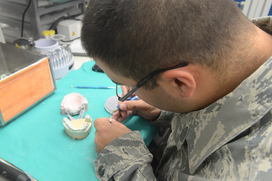 Senior Airman Dennis Davila, 56th DS dental laboratory technician, waxes a crown at Luke. 