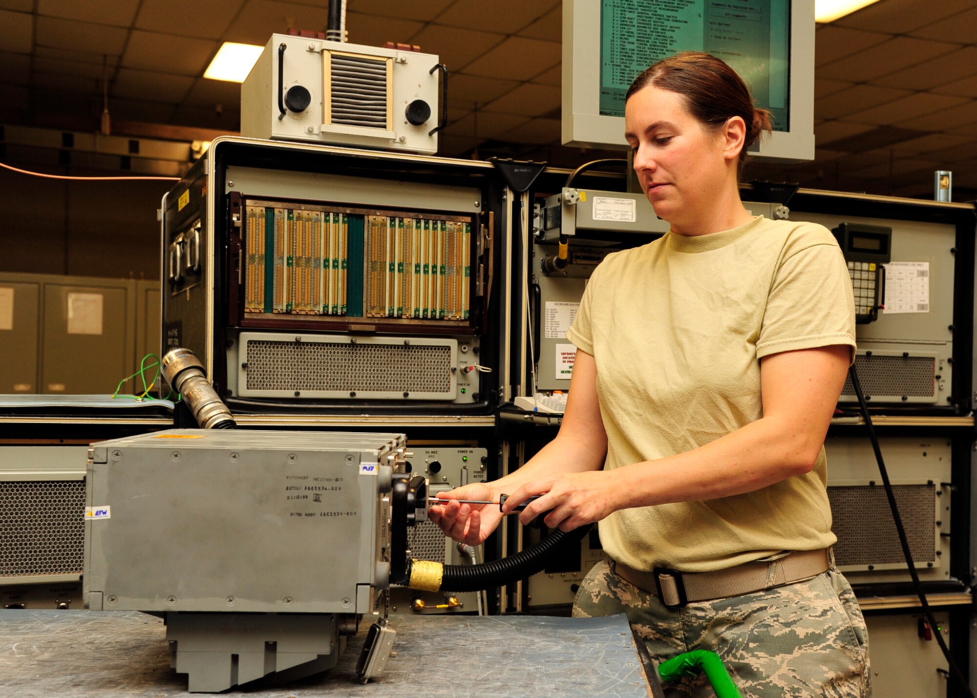 Caldwell removes the connector covers of an enhanced central interface unit, which controls the weapons system of an F-16 Fighting Falcon.  The AIS is a two level maintenance screening point for all the F-16s at Luke.