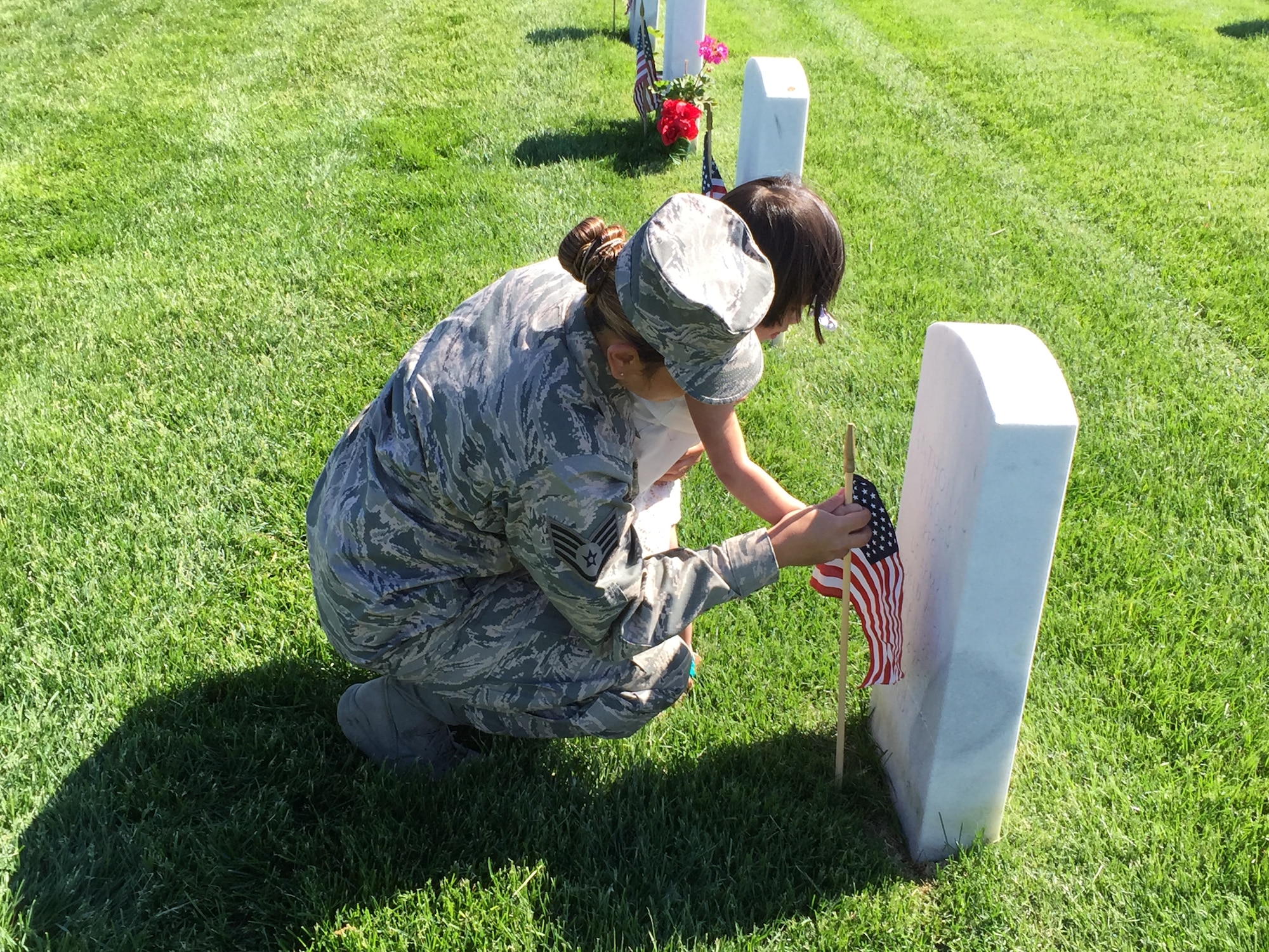 106th Rescue Wing medical technician Staff Sgt. Rendal-Sestoso and her daughter placing a small American flag by a gravestone at Calverton National Cemetery in commemoration of Memorial Day.

106th Rescue Wing members and more than 6,700 people decorated gravestones with small American flags at Calverton National Cemetery on Memorial Day weekend, May 23rd 2015.