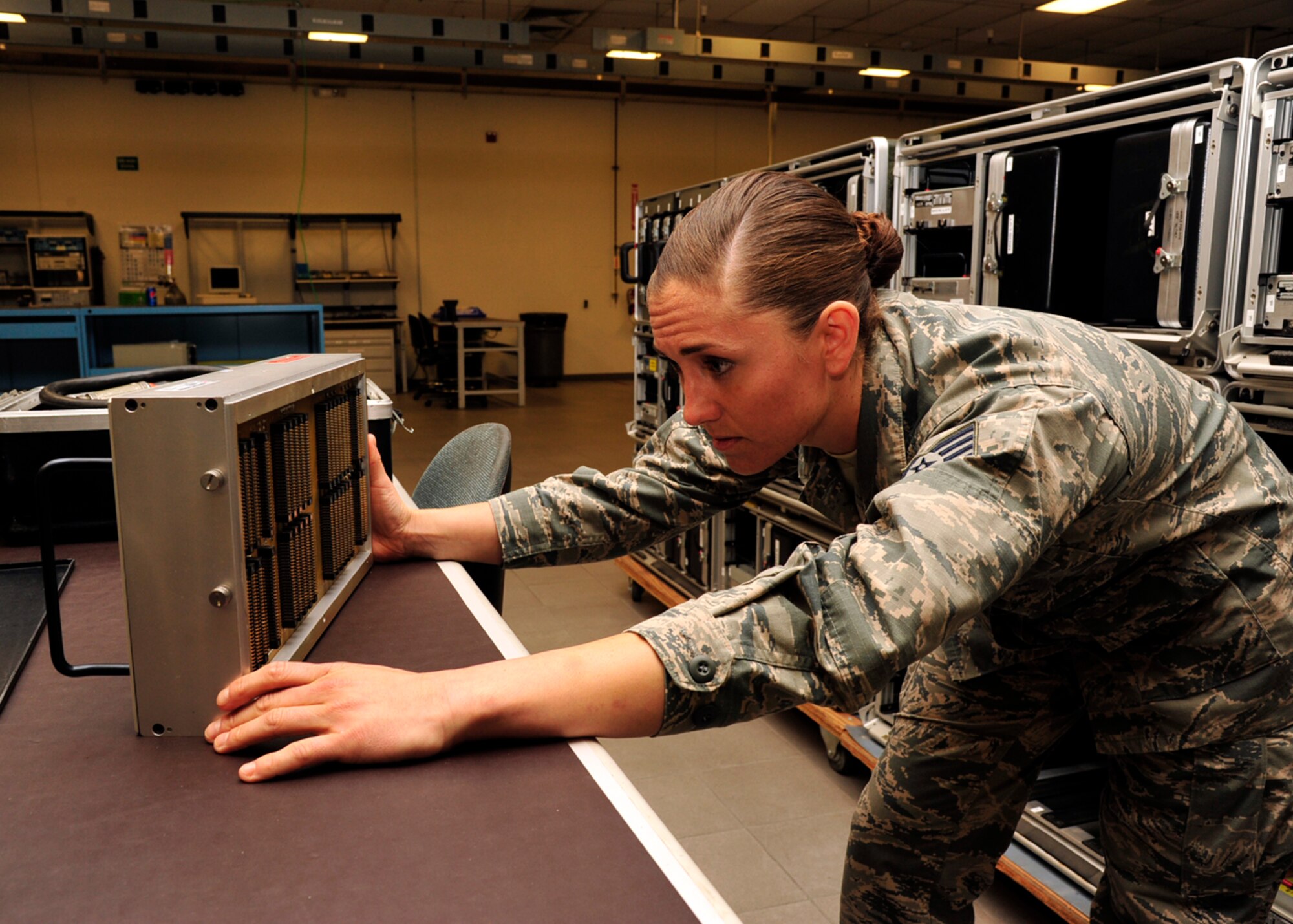 Staff Sgt. Meghan McDonald, 56th CMS AIS F-16 production supervisor, inspects a test adaptor for damage. In addition to each component having its own software program, each component has its own adaptor to plug into the test station. AIS Airmen can reset cards, replace small hardware, check for internal visible damage such as burnt components or broken pins and more. 