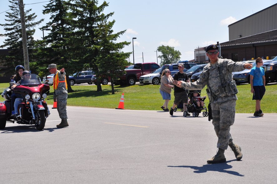 Senior Airman Nathan McLallen, 914th Security Forces Squadron, directs vehicular and pedestrian traffic during the 2015 Thunder of Niagara Air Show on July 19, 2015. More than 200 security personnel were used at traffic control points and entrances, as well as, providing public safety. (U.S. Air Force photo by Master Sgt. Kevin Nichols) 