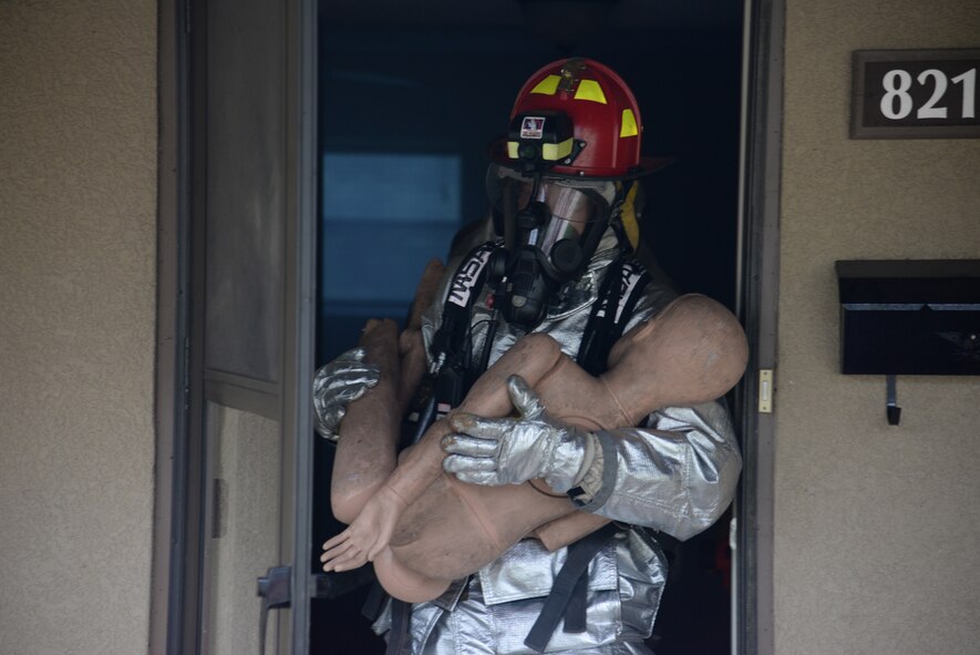 A Laughlin firefighter with the 47th Civil Engineer Squadron, rescues a (mannequin) victim during a structural training exercise at Laughlin Air Force Base, Texas, July 22, 2015. During a structural exercise, a house or structure with mannequins inside is filled with simulated smoke; the firefighters specific objective is to enter a facility and perform a right or left hand search pattern to locate and extinguish the fire, rescuing any trapped victims along the way. (U.S. Air Force photo by Airman 1st Class Brandon May) (Released)