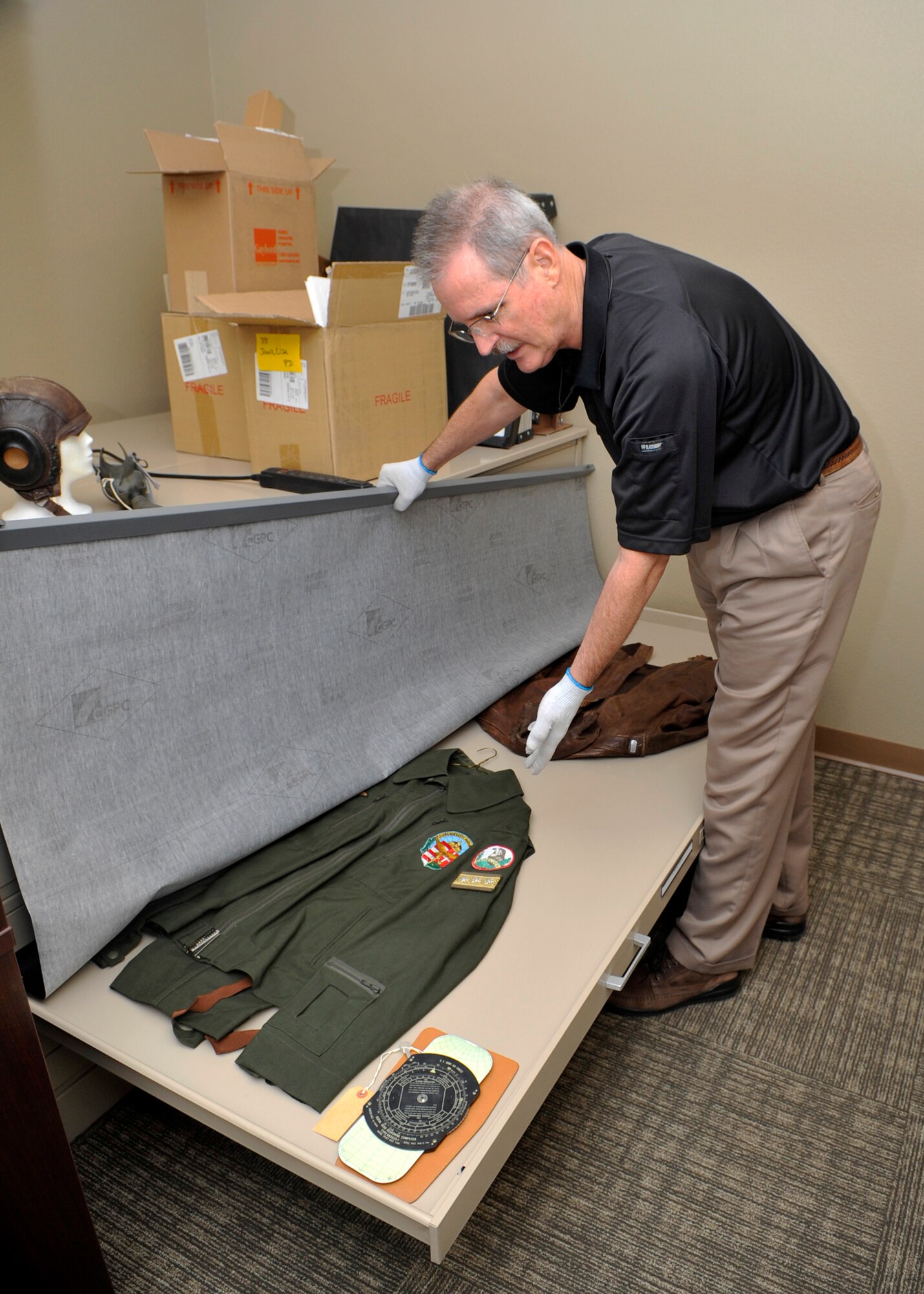 Richard Griset, 56th Fighter Wing historian, shows an old pilot uniform that is part of a preservation collection on Luke Air Force Base. 

Use both if you have room, or this one for sure.
