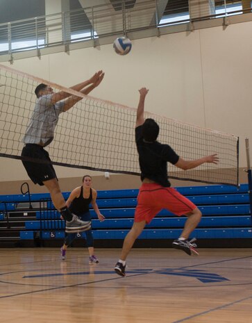 Airmen assigned to the 99th Medical Operations Squadron play volleyball at the Warrior Fitness Center on Nellis Air Force Base, Nev., July 21, 2015. Playing volleyball can help improve hand-eye coordination, and the sport is a cardiovascular exercise that helps strengthen the heart and lungs. Playing volleyball also helps build speed and agility due to quick changes of pace and direction. (U.S. Air Force photo by Airman 1st Class Mikaley Towle)