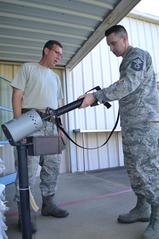 Tech. Sgt. Robert Custer, 111th Logistics Readiness Squadron supervisor supply technician, stands watch as Master Sgt. John Riccio, 103rd Attack Squadron non-commissioned officer in charge of standardization and evaluation, clears his rifle in preparation for transport of the 111th Attack Wing’s marksmanship team to the Governor’s Twenty competition. The annual marksmanship event is a National Guard-wide match during which the state’s top military marksmen fire both rifle and pistol. (U.S. Air National Guard photo by Tech. Sgt. Andria Allmond/Released)