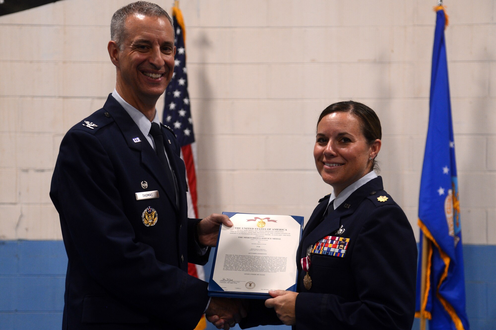 U.S. Air Force Maj. Jamie Wade, outgoing 20th Logistics Readiness Squadron commander, receives a Meritorious Service Medal from Col. John Thomas, 20th Mission Support Group commander, during the 20th LRS change of command ceremony at Shaw Air Force Base, S.C., July 23, 2015. The 20th LRS provides integrated logistics planning, supply, and transportation to the 20th Fighter Wing, Ninth Air Force, U.S. Air Forces Central, and tenant units. (U.S. Air Force photo by Senior Airman Jonathan Bass/Released)