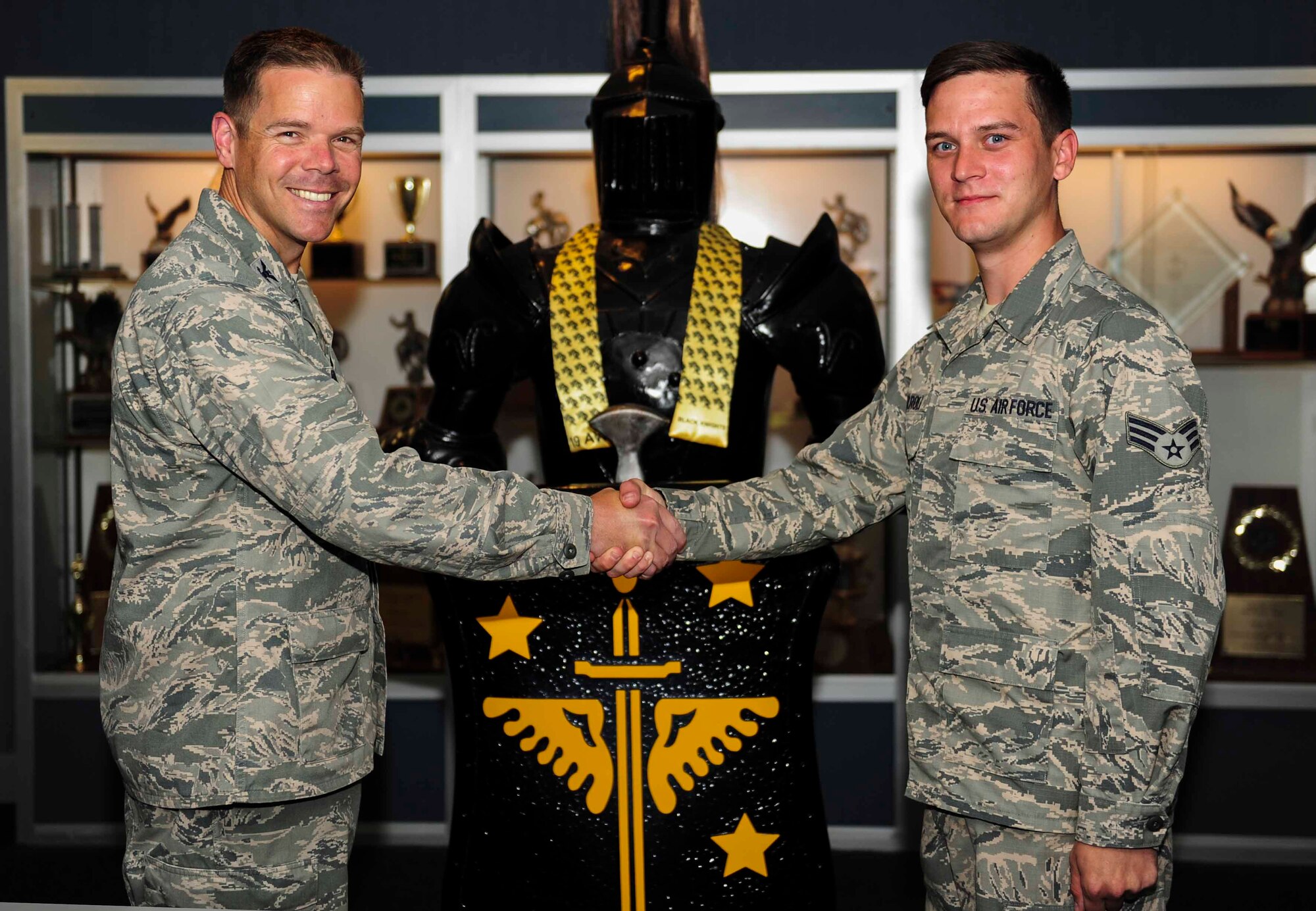 Col. Charles Brown, 19th Airlift Wing commander, congratulates Senior Airman Mark Carroll 19th Logistics Readiness Squadron aircraft services element member, for his selection as Combat Airlifter of the week July 20, 2015, at Little Rock Air Force Base, Ark. Carroll plays a critical role in loading the airdrop assets that provide 63 percent of the Department of Defense’s tactical airdrop training to three major commands and enables the training and qualification of more than 1,800 aircrew members annually. (U.S. Air Force photo by Senior Airman Kaylee Clark)