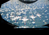 Five members of the U.S. Air Force Thunderbirds fly in formation behind a KC-135 Stratotanker assigned to McConnell Air Force Base, Kan, July 23, 2015. The Thunderbirds are the Air Force’s premiere air demonstration team and perform at different events across the country every year. They are often accompanied from one stop to another by an Air Force tanker aircraft to provide a quick, non-stop route between performances. (U.S. Air Force photo by Senior Airman Victor J. Caputo)