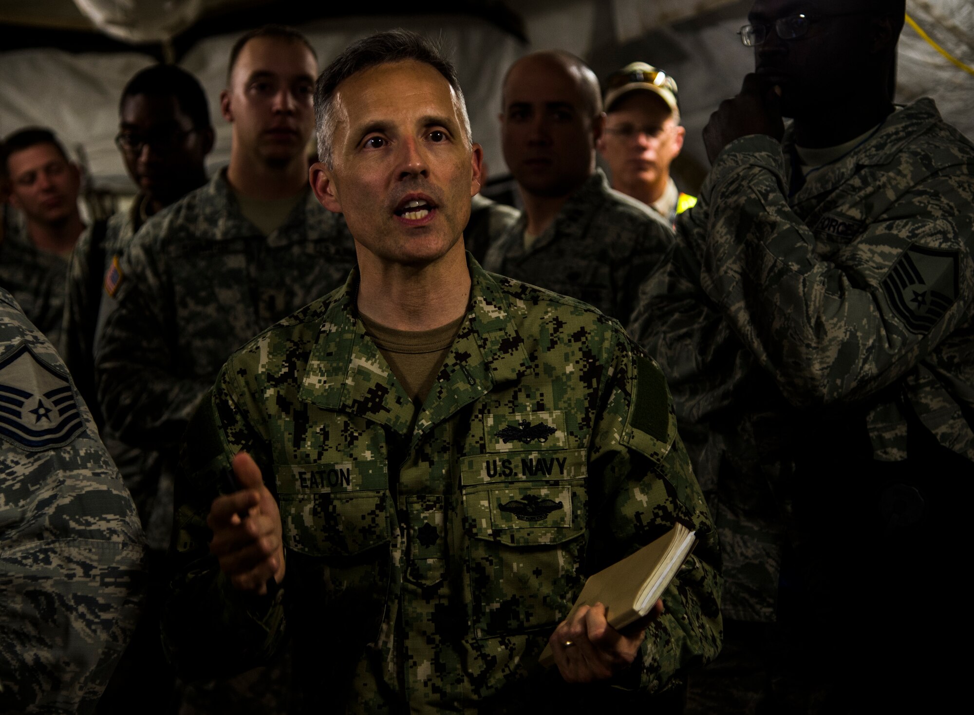 U.S. Navy Cmdr. Greg Eaton, Defense Logistics Agency support team commander, speaks during an update brief during exercise Turbo Distribution 15-7 at Joint Base McGuire-Dix-Lakehurst, N.J., July 22, 2015. Approximately 106 Airmen stationed at Travis Air Force Base, Calif., assigned to the 621st Contingency Response Wing, along with approximately 51 U.S. Army Soldiers assigned to the 690th Rapid Port Opening Element stationed at Joint Base Langley-Eustis, Va., and three members of the Defense Logistics Agency participated in the exercise, combining to make a Joint Task Force-Port Opening team. During the exercise, the U.S. Transportation Command tested the ability of the JTF-PO to distribute cargo during a humanitarian mission. (U.S. Air Force photo/Staff Sgt. Gustavo Gonzalez/RELEASED)