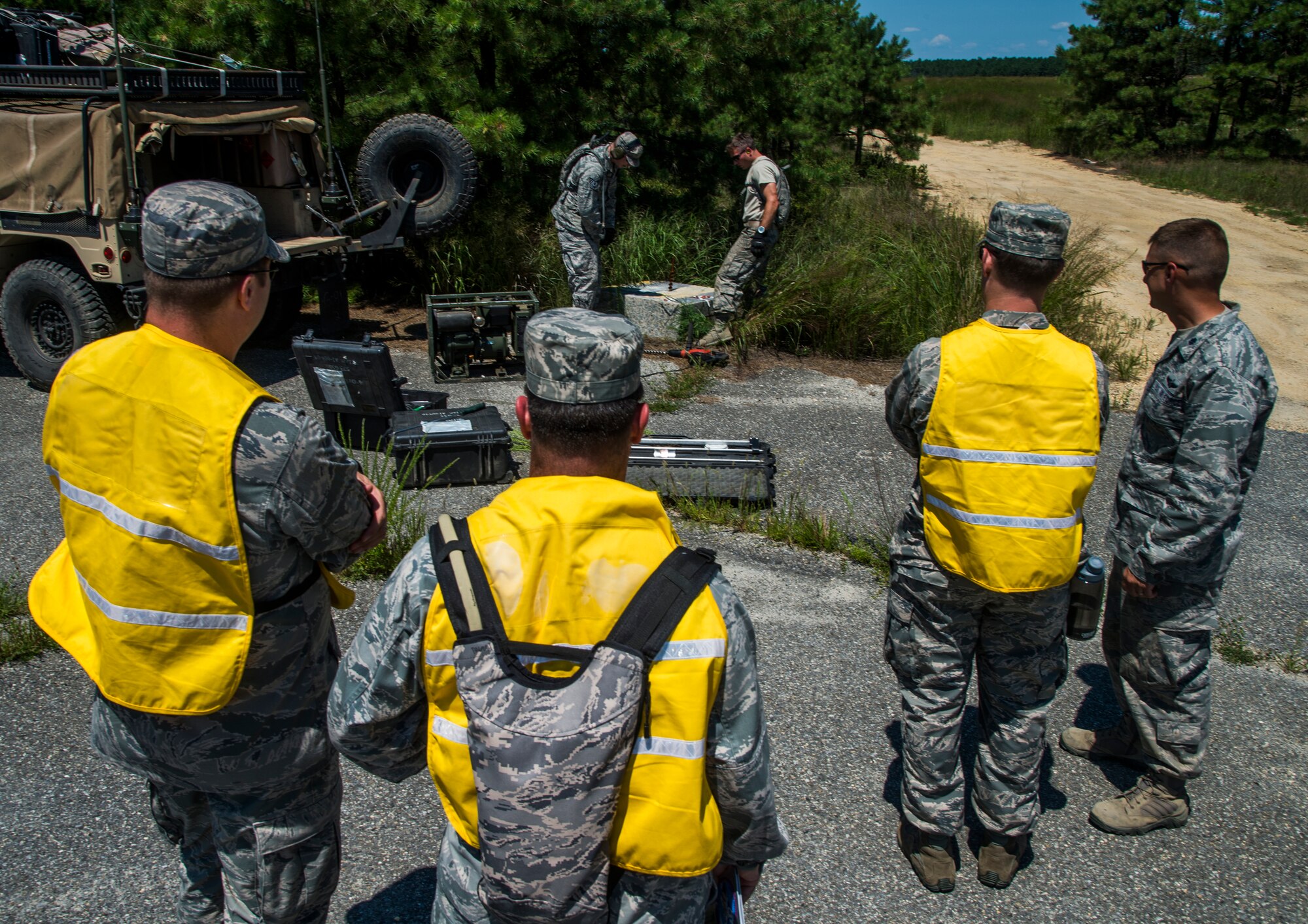 U.S. Air Force Airmen from the U.S. Transportation Command and the 621st Contingency Response Wing assess Airmen conducting an airfield assessment during exercise Turbo Distribution 15-7 at Joint Base McGuire-Dix-Lakehurst, N.J., July 22, 2015. Approximately 106 Airmen stationed at Travis Air Force Base, Calif., assigned to the CRW, along with approximately 51 U.S. Army Soldiers assigned to the 690th Rapid Port Opening Element stationed at Joint Base Langley-Eustis, Va., and three members of the Defense Logistics Agency participated in the exercise, combining to make a Joint Task Force-Port Opening team. During the exercise, the U.S. Transportation Command tested the ability of the JTF-PO to distribute cargo during a humanitarian mission. (U.S. Air Force photo/Staff Sgt. Gustavo Gonzalez/RELEASED)