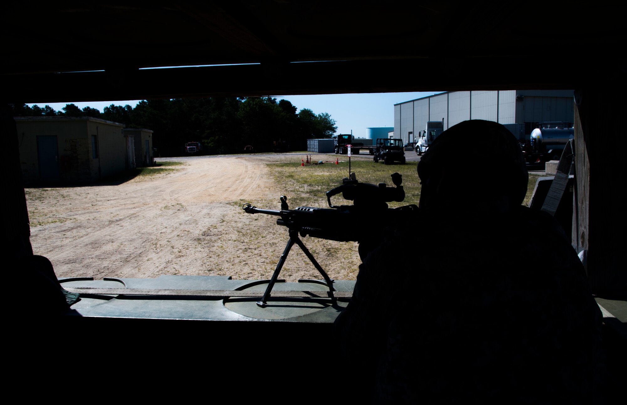 U.S. Air Force Senior Airman Alex Gibson, assigned to the 621st Contingency Response Wing, is ready at a defensive fighting position during exercise Turbo Distribution 15-7 at Joint Base McGuire-Dix-Lakehurst, N.J., July 22, 2015. Approximately 106 Airmen stationed at Travis Air Force Base, Calif., assigned to the CRW, along with approximately 51 U.S. Army Soldiers assigned to the 690th Rapid Port Opening Element stationed at Joint Base Langley-Eustis, Va., and three members of the Defense Logistics Agency participated in the exercise, combining to make a Joint Task Force-Port Opening team. During the exercise, the U.S. Transportation Command tested the ability of the JTF-PO to distribute cargo during a humanitarian mission. (U.S. Air Force photo/Staff Sgt. Gustavo Gonzalez/RELEASED)
