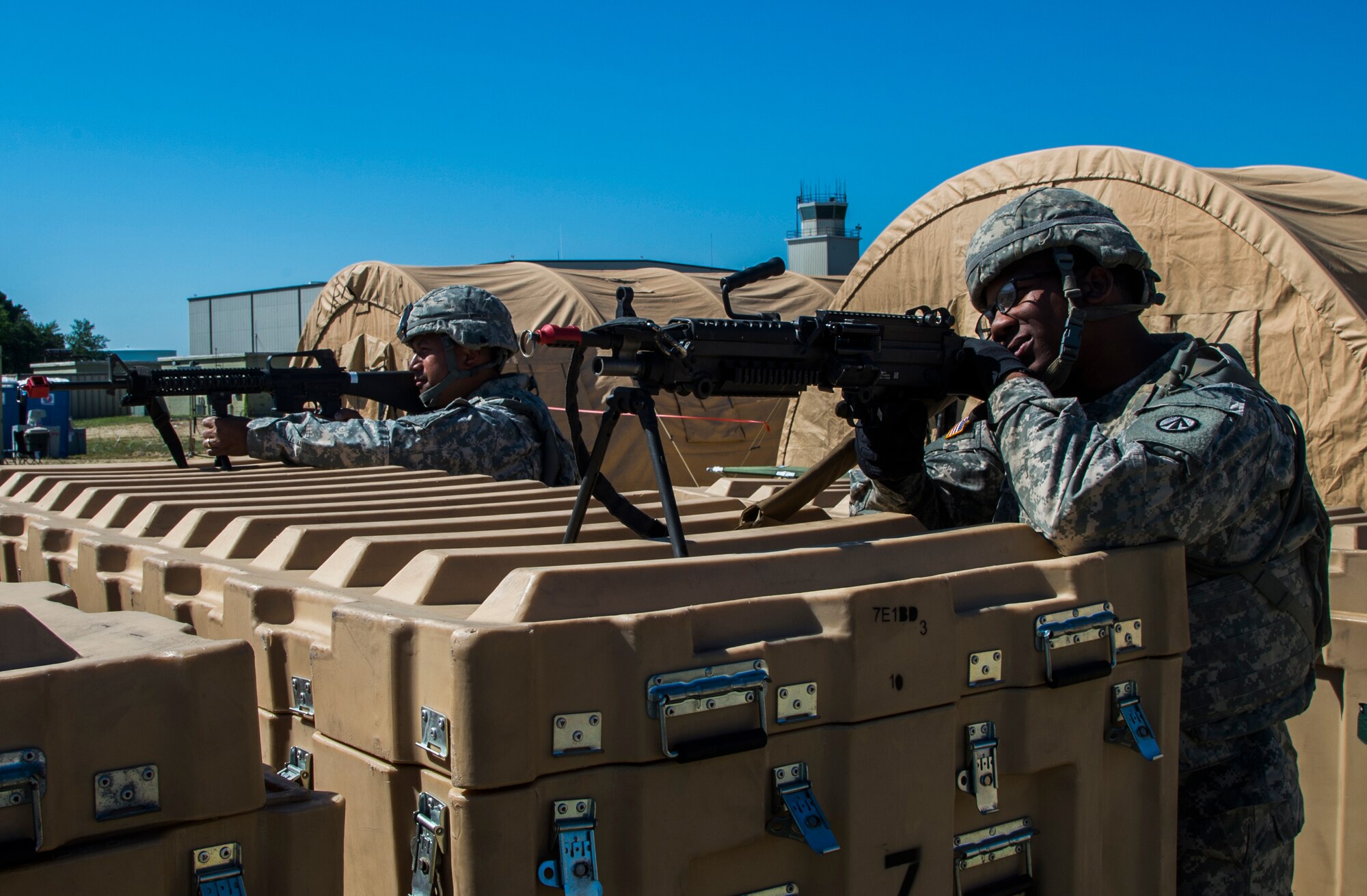 U.S. Army Spc. DaQuan Mann and Sgt. Robin Mailo are set ready at a defensive fighting position during exercise Turbo Distribution 15-7 at Joint Base McGuire-Dix-Lakehurst, N.J., July 22, 2015. Approximately 106 Airmen stationed at Travis Air Force Base, Calif., assigned to the CRW, along with approximately 51 Soldiers stationed at Joint Base Langley-Eustis, Va., and three members of the Defense Logistics Agency participated in the exercise, combining to make a Joint Task Force-Port Opening team. During the exercise, the U.S. Transportation Command tested the ability of the JTF-PO to distribute cargo during a humanitarian mission. (U.S. Air Force photo/Staff Sgt. Gustavo Gonzalez/RELEASED)