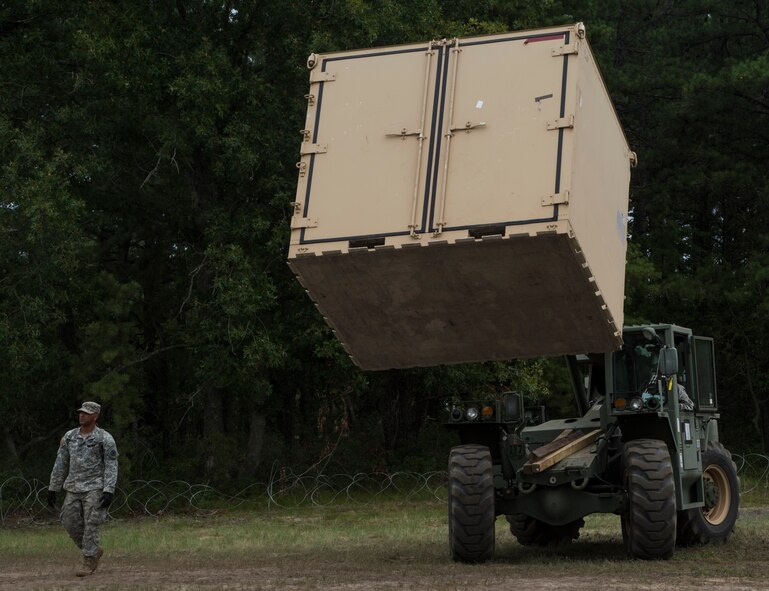 U.S. Army Soldiers assigned to the 690th Rapid Port Opening Element stationed at Joint Base Langley-Eustis, Va., use a forklift to load cargo onto trucks during exercise Turbo Distribution 15-7 at Joint Base McGuire-Dix-Lakehurst, N.J., July 21, 2015. Approximately 51 Soldiers along with approximately 106 U.S. Airmen stationed at Travis Air Force Base, Calif., assigned to the 621st Contingency Response Wing, and three members of the Defense Logistics Agency participated in the exercise, combining to make a Joint Task Force-Port Opening team. During the exercise, the U.S. Transportation Command tested the ability of the JTF-PO to distribute cargo during a humanitarian mission. (U.S. Air Force photo/Staff Sgt. Gustavo Gonzalez/RELEASED)