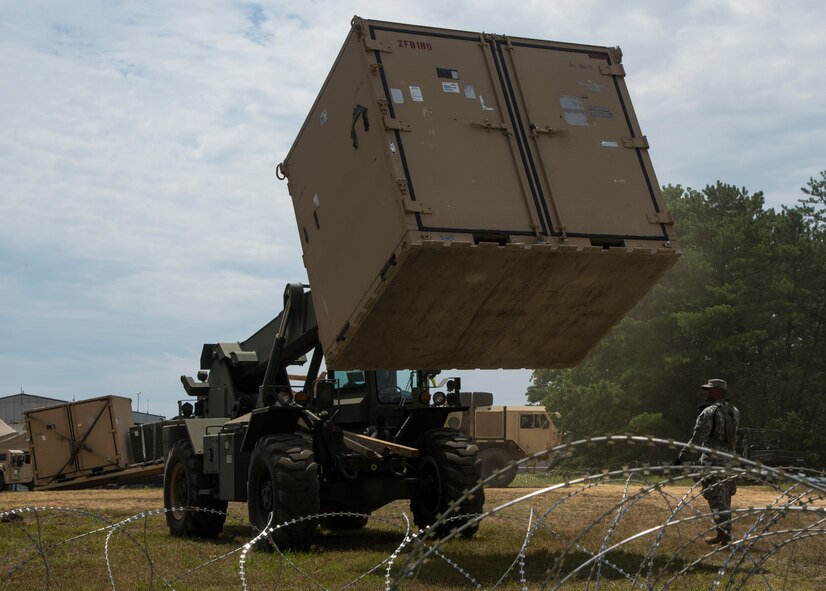 U.S. Army Soldiers assigned to the 690th Rapid Port Opening Element stationed at Joint Base Langley-Eustis, Va., use forklifts to load cargo onto trucks during exercise Turbo Distribution 15-7 at Joint Base McGuire-Dix-Lakehurst, N.J., July 21, 2015. Approximately 51 Soldiers along with approximately 106 U.S. Airmen stationed at Travis Air Force Base, Calif., assigned to the 621st Contingency Response Wing, and three members of the Defense Logistics Agency participated in the exercise, combining to make a Joint Task Force-Port Opening team. During the exercise, the U.S. Transportation Command tested the ability of the JTF-PO to distribute cargo during a humanitarian mission. (U.S. Air Force photo/Staff Sgt. Gustavo Gonzalez/RELEASED)