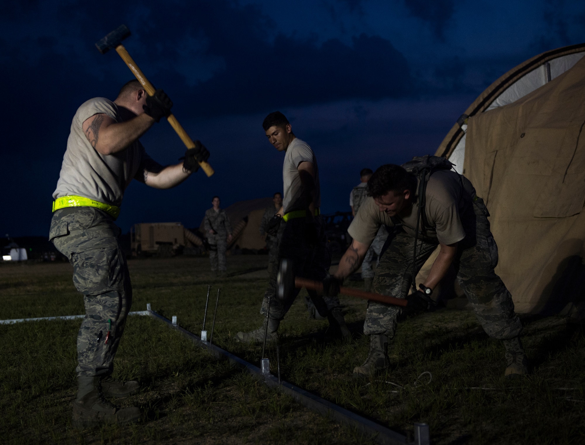U.S. Air Force Airmen assigned to the 621st Contingency Response Wing help set up tents during exercise Turbo Distribution 15-7 at Joint Base McGuire-Dix-Lakehurst, N.J., July 20, 2015. Approximately 106 Airmen stationed at Travis Air Force Base, Calif., assigned to the CRW, along with approximately 51 U.S. Army Soldiers assigned to the 690th Rapid Port Opening Element stationed at Joint Base Langley-Eustis, Va., and three members of the Defense Logistics Agency participated in the exercise, combining to make a Joint Task Force-Port Opening team. During the exercise, the U.S. Transportation Command tested the ability of the JTF-PO to distribute cargo during a humanitarian mission. (U.S. Air Force photo/Staff Sgt. Gustavo Gonzalez/RELEASED)