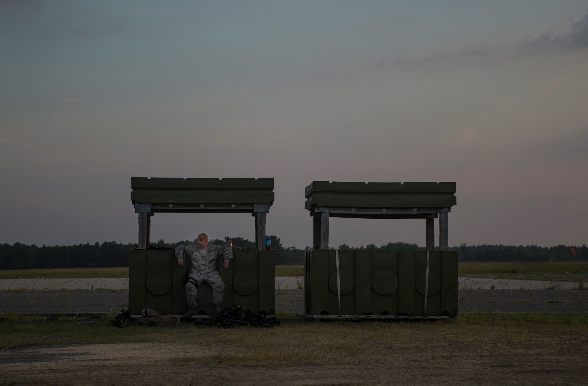 An Airman assigned to the 621st Contingency Response Wing guards M4 rifles during exercise Turbo Distribution 15-7 at Joint Base McGuire-Dix-Lakehurst, N.J., July 20, 2015. Approximately 106 Airmen stationed at Travis Air Force Base, Calif., assigned to the CRW, along with approximately 51 U.S. Army Soldiers assigned to the 690th Rapid Port Opening Element stationed at Joint Base Langley-Eustis, Va., and three members of the Defense Logistics Agency participated in the exercise, combining to make a Joint Task Force-Port Opening team. During the exercise, the U.S. Transportation Command tested the ability of the JTF-PO to distribute cargo during a humanitarian mission. (U.S. Air Force photo/Staff Sgt. Gustavo Gonzalez/RELEASED)