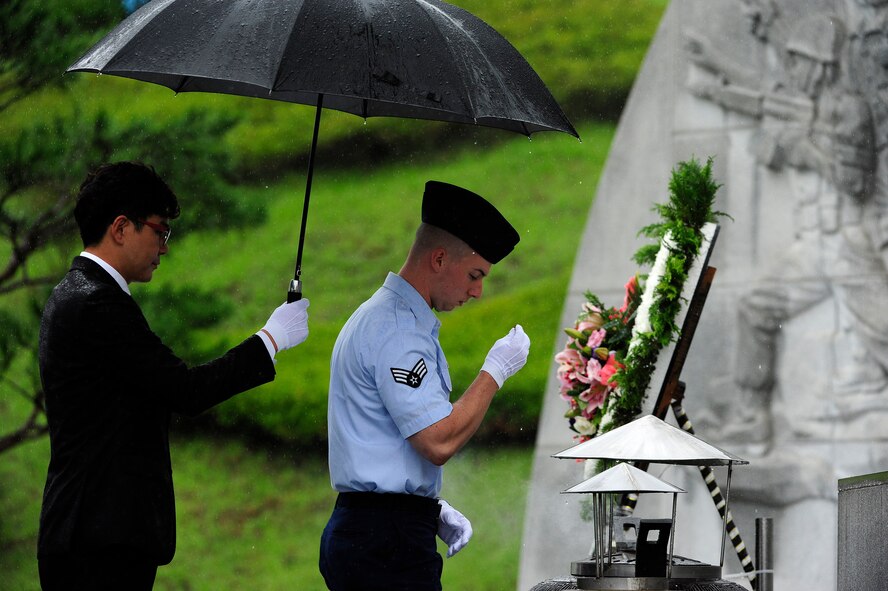 Senior Airman Drew Hagen, 8th Maintenance Group, Kunsan Air Base, Republic of Korea, transfers incense to an urn with ceremonial gloves during the official proceedings of a Korean Armistice Agreement anniversary ceremony at Imsil National Cemetery, ROK, July 24, 2015. The incense was burned in the accompanying urn in remembrance of the lives lost and the sacrifices made during the Korean War. (U.S. Air Force photo by Staff Sgt. Nick Wilson/Released)
