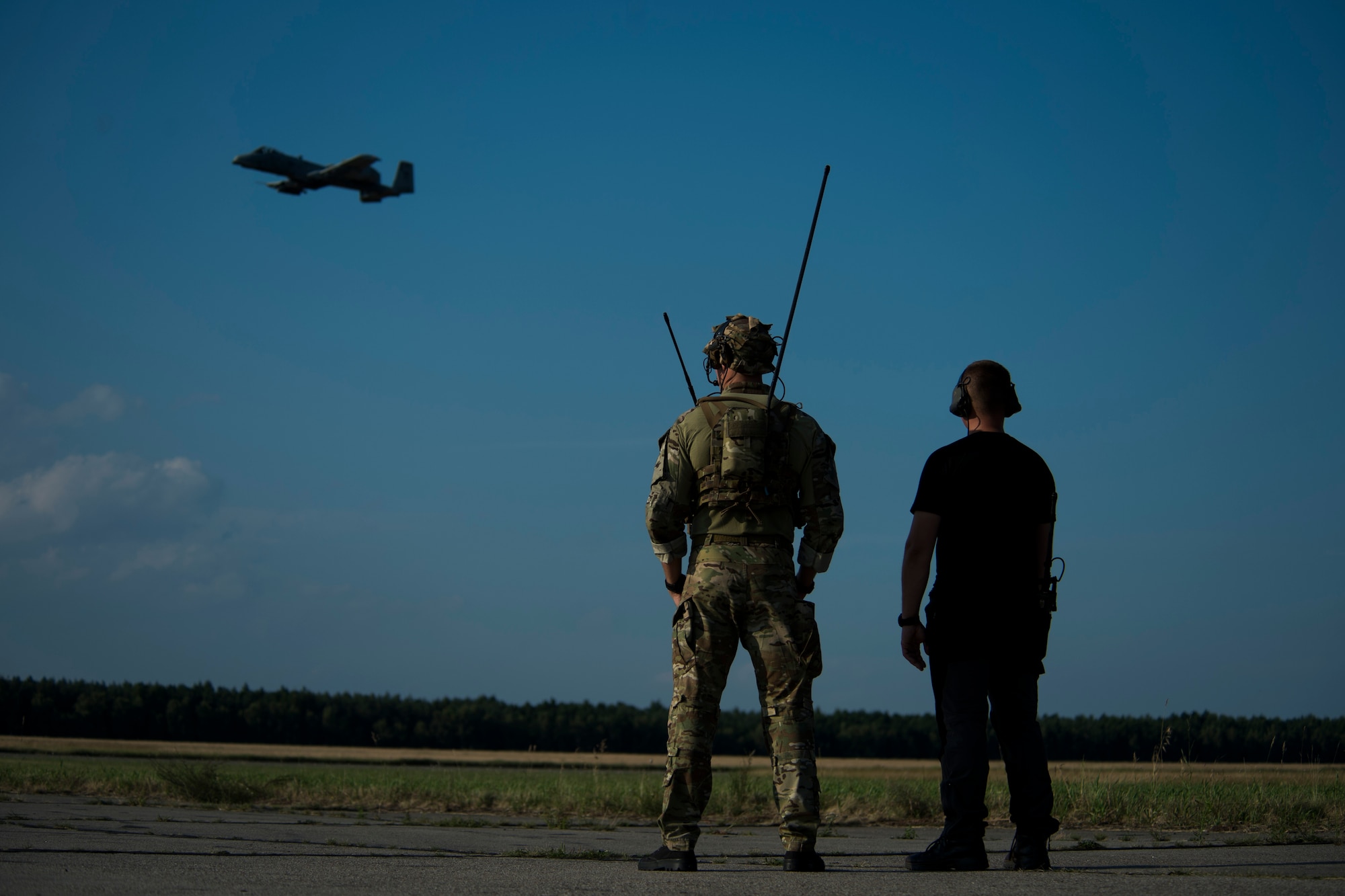 A 321st Special Tactics Squadron combat controller, left, and a member of the Polish Special Forces view an A-10C Thunderbolt II aircraft flying past during training at Nowe Miasto, Poland, July 21, 2015. The 321st STS worked directly with the PSF to display how combat controllers set up an austere landing strip, communicate landing tactics with pilots and marshal aircraft after they have landed. The aircraft deployed to Poland in support of Operation Atlantic Resolve to bolster air power capabilities while underscoring the U.S. commitment to European security and stability.  (U.S. Air Force photo by Airman 1st Class Luke Kitterman/Released)