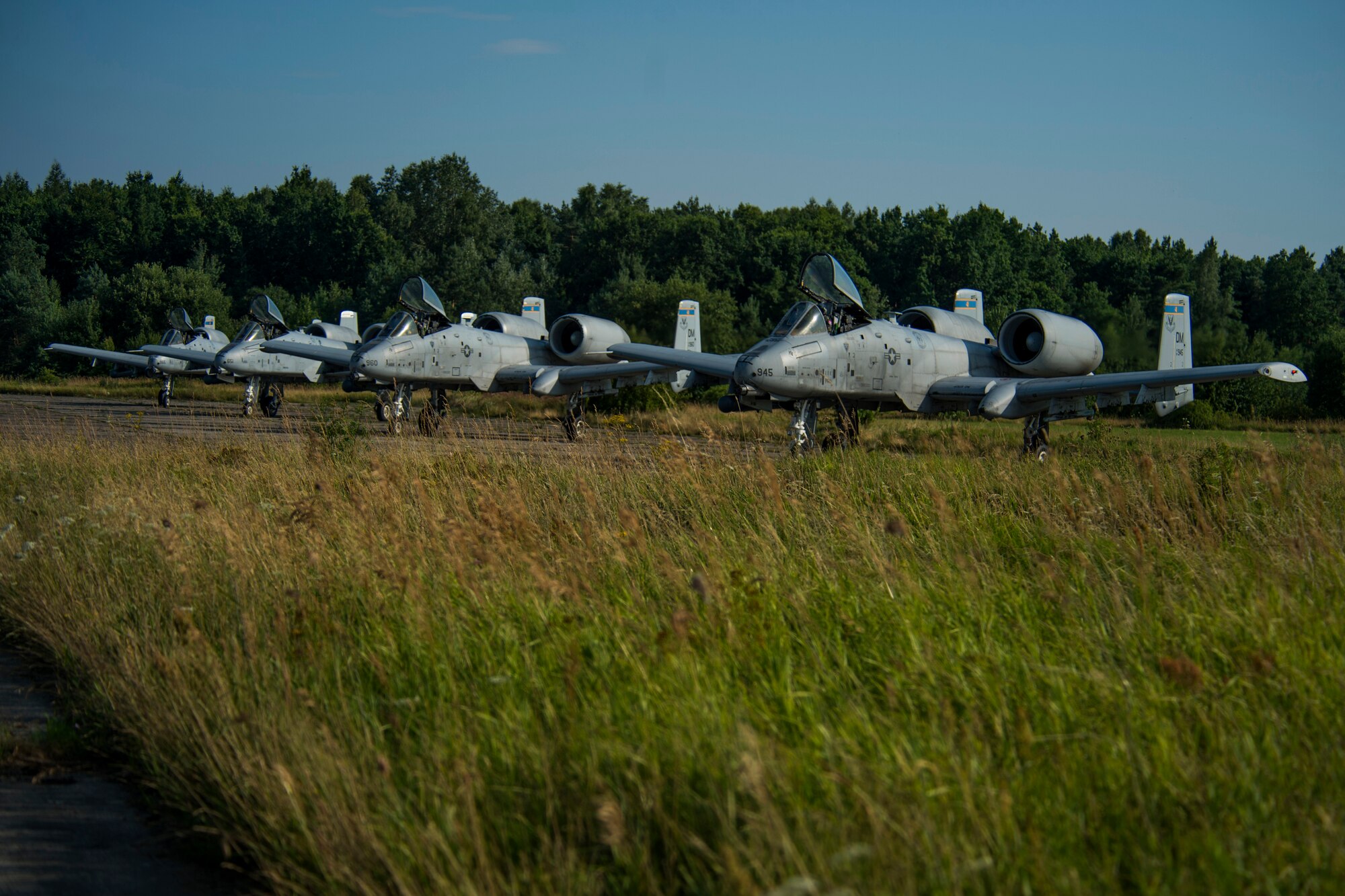 Four A-10C Thunderbolt II aircraft from the 354th Expeditionary Fighter Squadron line up during austere landing training at Nowe Miasto, Poland, July 21, 2015. Pilots performed landings on the unimproved surface during both day and night. Pilots will use night vision goggles when there is no available light. The aircraft deployed to Poland in support of Operation Atlantic Resolve to bolster air power capabilities while underscoring the U.S. commitment to European security and stability. (U.S. Air Force photo by Airman 1st Class Luke Kitterman/Released)