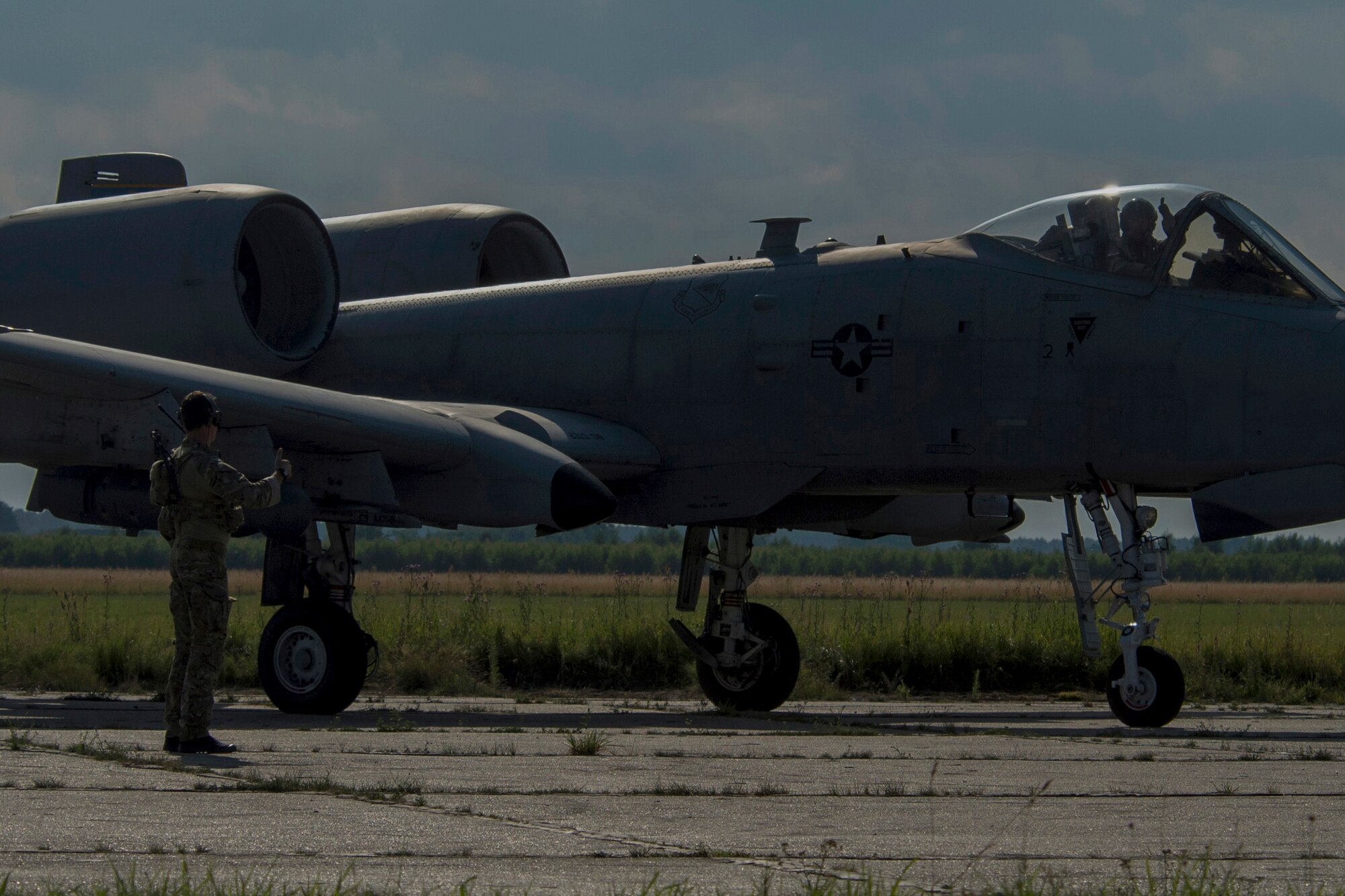 A 321st Special Tactics Squadron combat controller and a 354th Expeditionary Fighter Squadron A-10C Thunderbolt II pilot exchange a “thumbs up” during austere landing training at Nowe Miasto, Poland, July 21, 2015. Combat controllers ensure the environment is suitable for the aircraft commence austere landing training. The U.S. and Polish air forces will conduct training aimed to strengthen interoperability and demonstrate the countries' shared commitment to the security and stability of Europe. (U.S. Air Force photo by Airman 1st Class Luke Kitterman/Released)