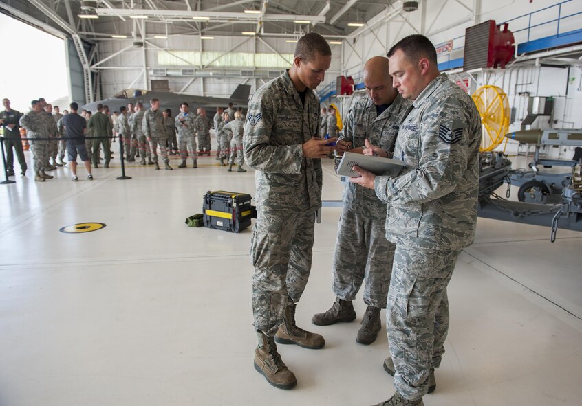 Airmen acting as judges for the 33rd Maintenance Group weapons standardization section calculate the results of a weapons load competition on Eglin Air Force Base, Fla., July 10, 2015. The competition was the first time teams faced off in a shotgun start event to load munitions on side-by-side F-35A Lightning IIs. (U.S. Air Force Photo/Staff Sgt. Marleah Robertson)