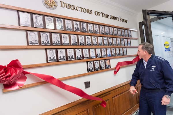 Lieutenant Gen. David Goldfein, Director of the Joint Staff, cuts the ribbon on the new portrait board that officials unveiled at the Pentagon, July 23, 2015. The board contains the images of past directors of the Joint Staff.