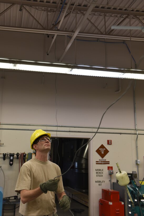 Staff Sgt. Keith Ruhl, cable and antenna systems technician, 211th Engineering Installation Squadron, runs a cable across the ceiling of the aircraft fabrication shop to install a paging system for the building. The installation of the paging system will help to alert the building in case of an emergency and is one of the four projects tasked to the 211th EIS as part of Exercise Frosty Spear, July 13-24, 168th Air Refueling Wing, Eielson Air Force Base, Fairbanks, Alaska. (U.S. Air National Guard photo by Staff Sgt. Claire Behney)