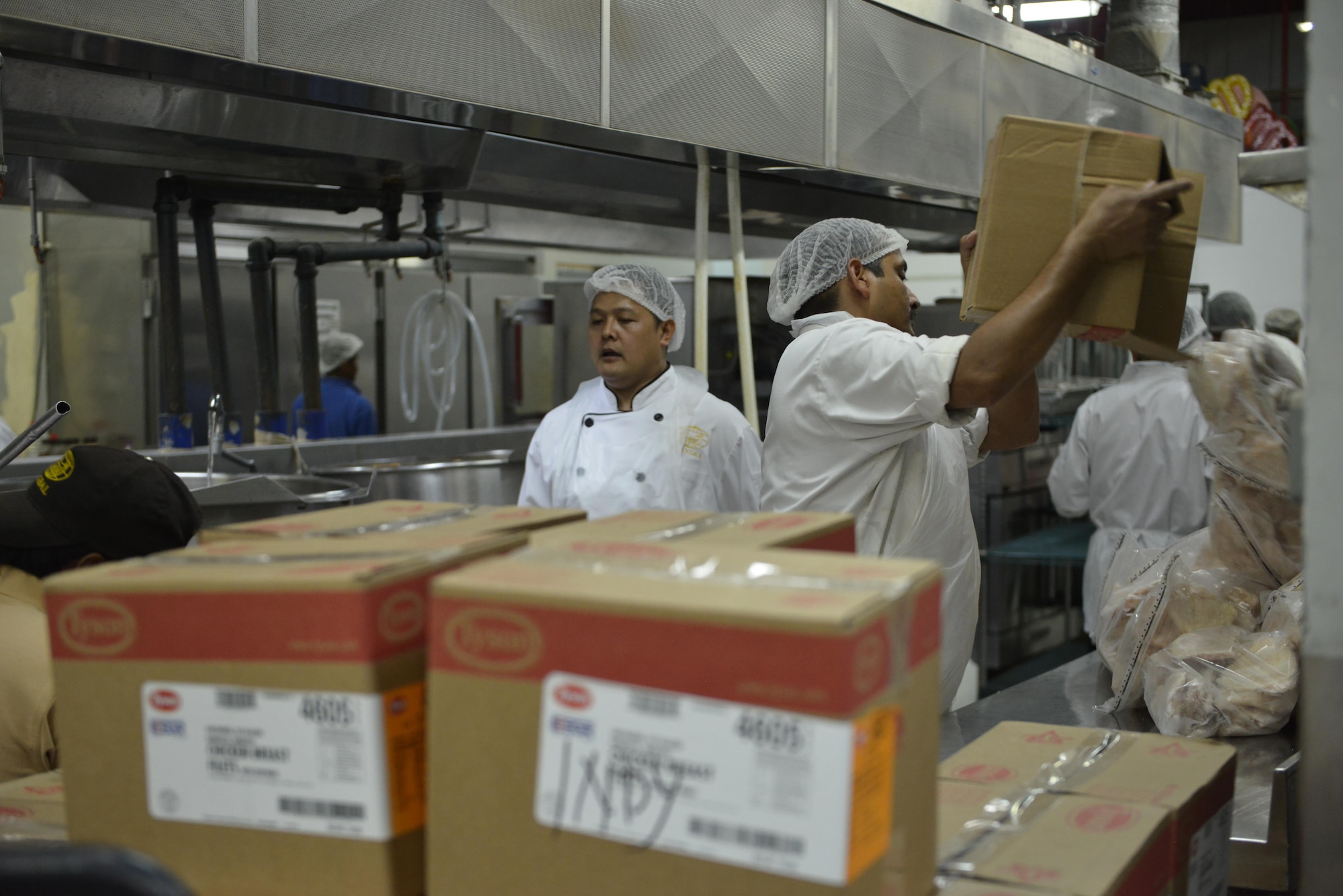 Dining facility cooks unpack a pallet of frozen chicken to start preparing for the dinner menu at the Independence Dinning Facility at Al Udeid Air Base, Qatar July 21, 2015. On an average day, 7,000 deployed members consume at least one pallet of chicken per dining facility here at Al Udeid.  (U.S. Air Force photo/Staff Sgt. Alexandre Montes)