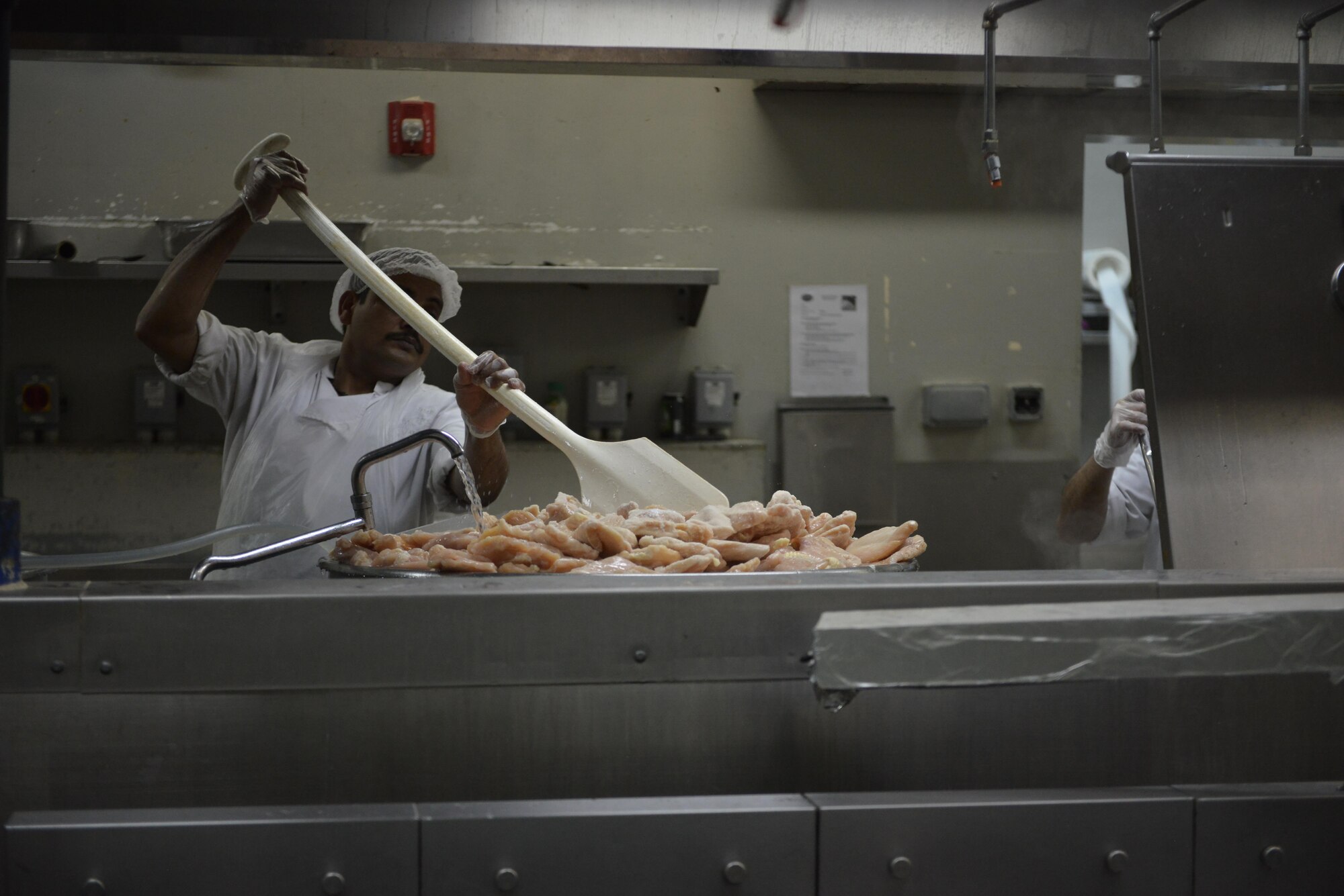 A dining facility cook thaws a pallet’s worth of chicken to help prepare for the dinner menu freezer at the Independence Dining Facility at Al Udeid Air Base, Qatar July 21, 2015. (U.S. Air Force photo/Staff Sgt. Alexandre Montes)
