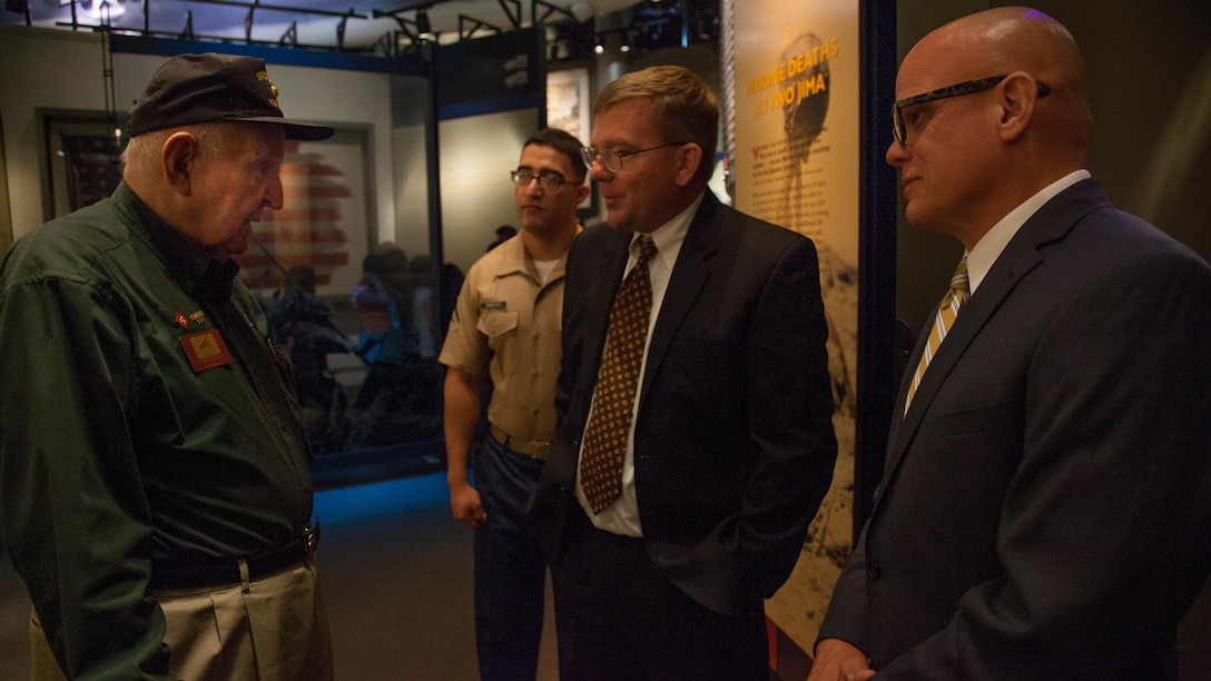 Mark Noah, center, the executive director of History Flight, speaks with Frank Matthews, left, a veteran of the Battle of Iwo Jima, before receiving the title of Honorary Marine during a ceremony held at the National Marine Corps Museum, at Triangle, Virginia, July 24. History flight has recovered the remains of several hundred Marines and sailors deemed unrecoverable at the conclusion of Battle of Tarwa. 