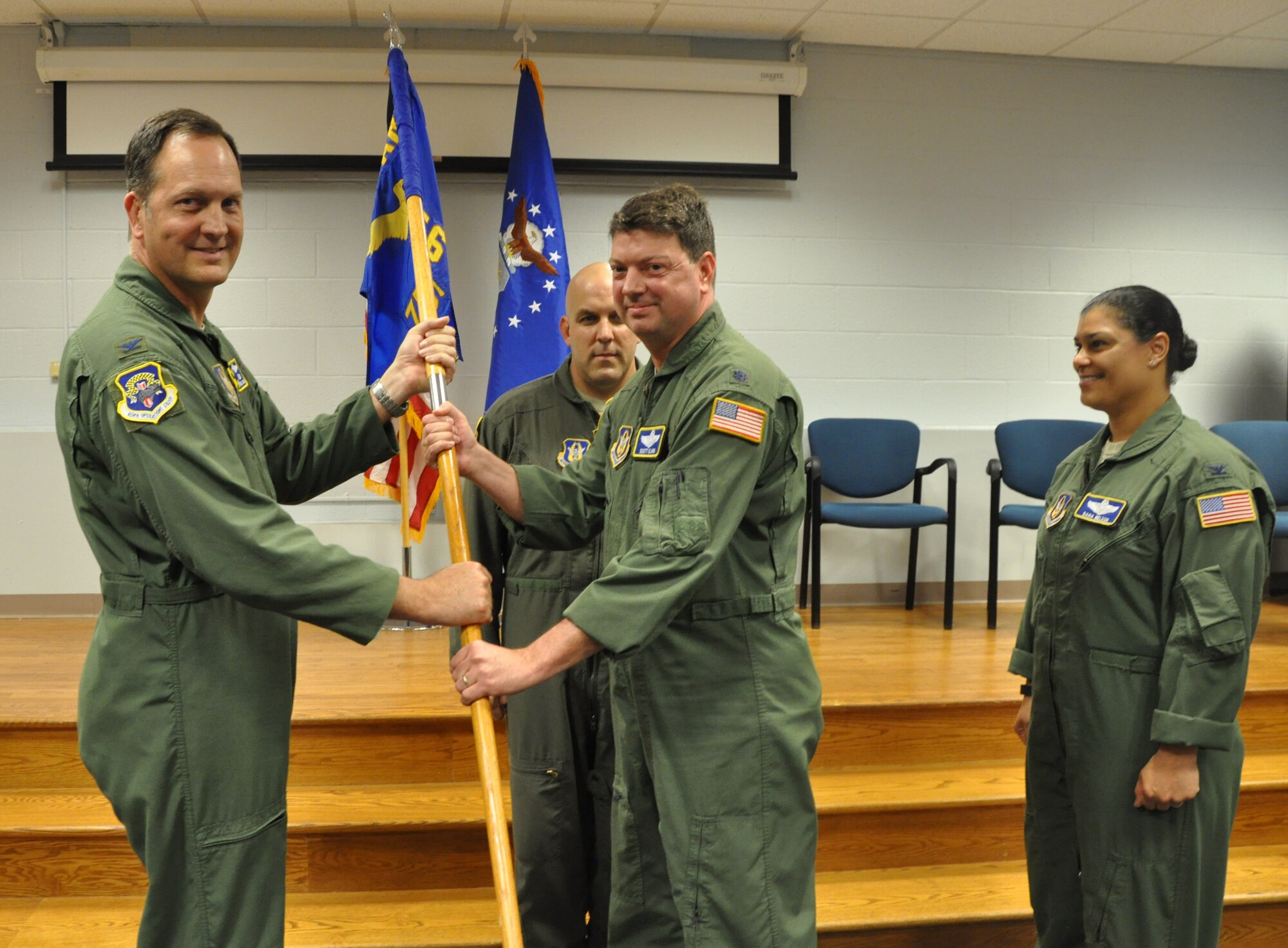 Col. Michael M. Moeding, 459th Operations Group commander, Joint Base Andrews, Md., passes the guidon to Lt. Col. Scott R. Clark, during the 756th Air Refueling Squadrons’ Change of Command ceremony held in the Aeromedical Evacuation Squadron auditorium on July 25, 2015. Col. Dana N. Nelson (right) served as commander there for two years. (U.S. Air Force photo / Staff Sgt. Amber J. Russell)