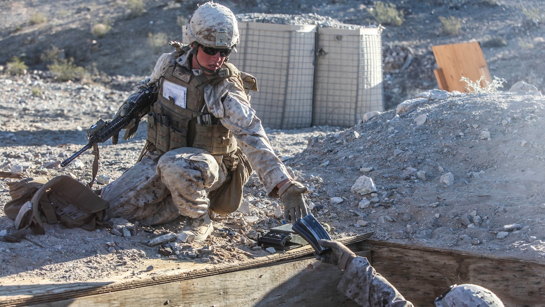Two Marines with 1st Platoon, Company C, 1st Battalion, 7th Marines, distribute ammunition during platoon attack drills, July 24, aboard Marine Corps Air Ground Combat Center Twentynine Palms, Calif. Training began for the Marines of Company C with a combined arms fire and maneuver exercise as part of their Integrated Training Exercise in preparation for their upcoming deployment with Special Purpose Marine Corps Air Ground Task Force Crisis Response Central Command 16.1 scheduled to depart later this year.
