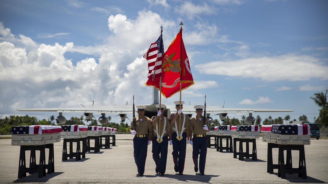 A 3rd Marine Regiment color guard takes its place, July 25, 2015, during a repatriation ceremony in Tarawa, Kiribati. The ceremony honored the remains of approximately 36 Marines who fought and died during the Battle of Tarawa during World War II, and were loaded onto a C-130J Hercules aircraft to be transported back home to the United States. 
