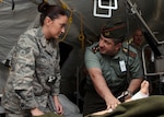 Republic of Armenia Ministry of Defense Capt. Ruben Khachatryan, chief of section, Central Military Medical Hospital, helps Senior Airman Michelle Kimball, a radiologic technologist assigned to the 192nd Medical Group, Virginia Air National Guard, take a simulated X-ray in the Expeditionary Medical Support (EMEDS) tent during PATRIOT exercise at Volk Field Combat Readiness Training Center, Wisconsin., July 21, 2015.