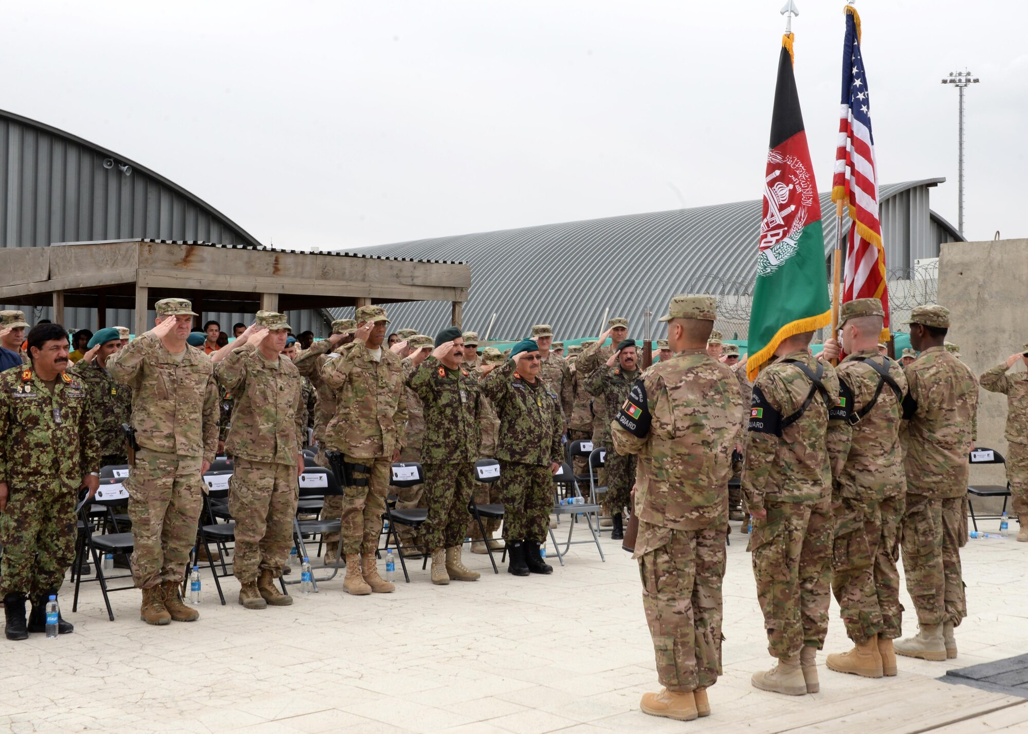 Coalition and Afghan military personnel salute the U.S. and Afghan flags at a change of command ceremony July 27, 2015, at Hamid Karzai International Airport, Kabul, Afghanistan. Brig. Gen. Christopher E. Craige took command of the Train, Advise, Assist Command – Air (TAAC-Air), 438th Air Expeditionary Wing. Presiding at the ceremony was Gen. John F. Campbell, commander, Resolute Support and U.S. Forces-Afghanistan. (U.S. Air Force photo by Senior Airman Cierra Presentado/Released)