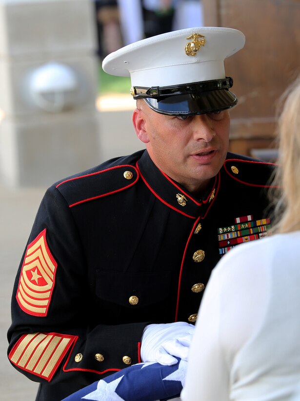 Sgt. Maj. Steven Battista, former Battery M, 3rd Battalion, 14th Marine Regiment Inspector Instructor, presents the American flag to Staff Sgt. David A. Wyatt’s wife. Wyatt, who was a field artillery operations man with Battery M, was laid to rest at the Chattanooga National Cemetery, July 24, 2015. Wyatt is one of five service members who died when a gunman attacked the Naval Operational Support Center and Marine Corps Reserve Center on July 16, 2015. Family and community members joined the Marines to honor Wyatt for making the ultimate sacrifice for his country. 