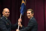 Col. Scott Lockwood, commander, Air Force Officer Training School, transfers command of Detachment 12 to Lt. Col. Loralie Rasmussen during a change of command ceremony July 16, 2015, Maxwell Air Force Base, Alabama. Rasmussen took command of the detachment from her husband, Lt. Col. Reid Rasmussen, who is attending Air War College here. 