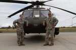 New York Army National Guard Warrant Officer Meghan Polis, left, and Chief Warrant Officer 3 Stephen Polis - a daughter and dad who are both assigned to Company B 3rd Battalion 142nd Assault Helicopter Battalion - pose in front of a UH-60 Black Hawk helicopter at Fort Drum July 22, 2015, before flying together as a pilot in command and pilot team. It was the first time both National Guard members flew together as pilots.