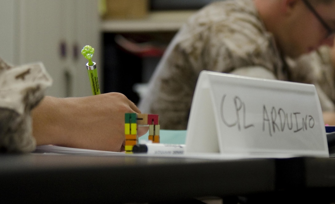 Cpl. William Arduino, the training noncommissioned officer with U.S. Marine Corps Forces, Pacific and Sleepy Hollow, N.Y., native, works on an activity during the Corporals for Financial Fitness Program class in classroom G of building 220 in the Education Center, July 23, 2015. The two-day class is held semi-annually aboard Marine Corps Base Hawaii, and is taught by the Personal Financial Management Program staff. The Marine Corps version of the Million Dollar Sailor Program, the course was established by Headquarters Marine Corps last year, and Marine Corps Order 1700.37 outlines the eligibility requirements for the class. Materials will be provided for this hands-on class, including colorful “fidgeting” toys, which aid in kinesthetic learning, a type of learning gained through physical activity. Marines are asked to bring their financial paperwork, such as their leave and earnings statement, and their bank statements. Among the requirements, students must undergo an interview with a PFMP staff member, be endorsed by their command and meet Marine Corps physical fitness standards. Jacqueline Walker, the PFMP manager, said the purpose of the class is to prepare corporals for “financial readiness” and to support their fellow Marines in the same. The mission of Marine Corps Base Hawaii provides facilities, programs and services in direct support of units, individuals and families in order to enhance and sustain combat readiness for all operating forces and tenant organizations aboard the installation. (U.S. Marine Corps photo by Kristen Wong/Released)