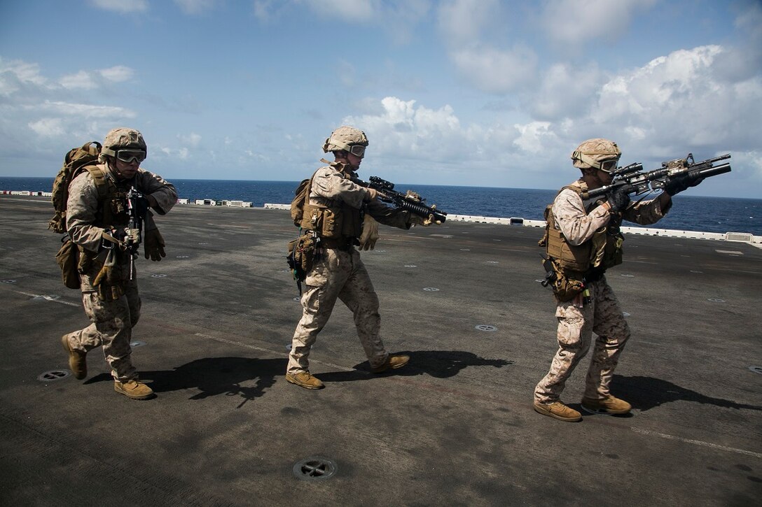 INDIAN OCEAN (July 24, 2015) U.S. Marines with the 15th Marine Expeditionary Unit’s Maritime Raid Force practice an initial clear after fast-roping aboard the amphibious assault ship USS Essex (LHD 2). These Marines are assigned to India Company, Battalion Landing Team 3rd Battalion, 1st Marine Regiment, 15th MEU, and are members of the MRF’s security element. The Marines practiced fast-roping onto the flight deck and simulated clearing the ship. Elements of the 15th MEU, based out of Camp Pendleton, California, and embarked aboard the Essex, are conducting naval operations in the 6th Fleet areas of operation in support of U.S. national security interests in Europe and Africa. (U.S. Marine Corps photo by Cpl. Anna Albrecht/Released)