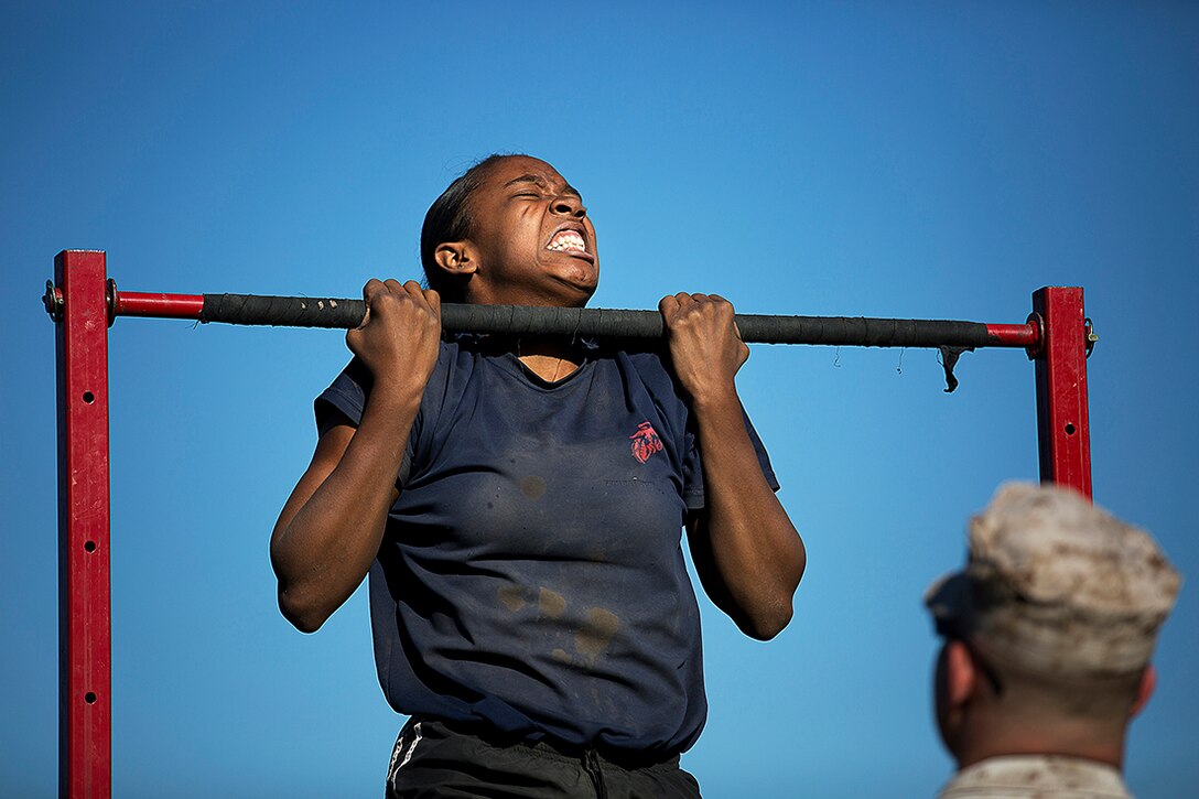 Myriah Monzon, a Marine enlistee from Gig Harbor, Wash., performs pull-ups under the watchful eye of Staff Sgt. Matthew Michael during the initial strength test portion of a Recruiting Station Seattle pool function at the Yakima Training Center in Yakima, Wash., July 17, 2015. During the event, recruiters teamed with drill instructors to physically and mentally prepare enlistees from Washington and Idaho for boot camp. The enlistees, part of the Marine Corps delayed entry program, are awaiting their ship dates. Monzon, 18, graduated from Peninsula High School and was recruited by Sgt. A.J. Russell. (U.S Marine Corps photo by Sgt. Reece Lodder)