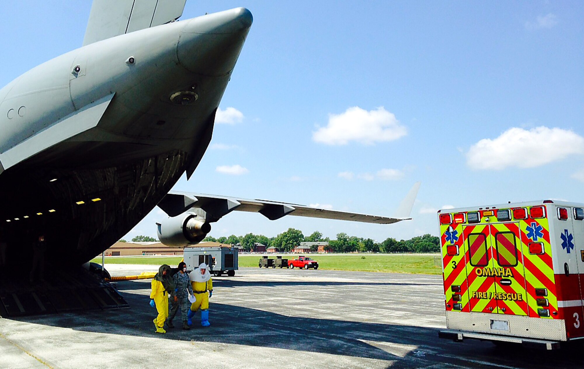 Omaha Fire and Rescue Department personnel in personal protective equipment transfer a simulated patient with a highly contagious disease to an ambulance on Offutt Air Force Base, Neb., July 23, 2015, as part of exercise Patriot 15. Three patients with simulated illnesses were airlifted from Volk Field, Wis., to Offutt AFBfor transfer to the University of Nebraska Medical Center’s Biocontainment Unit. The annual exercise, sponsored by the National Guard Bureau, is used to practice domestic operations within the U.S. (U.S. Air Force photo/Delanie Stafford)