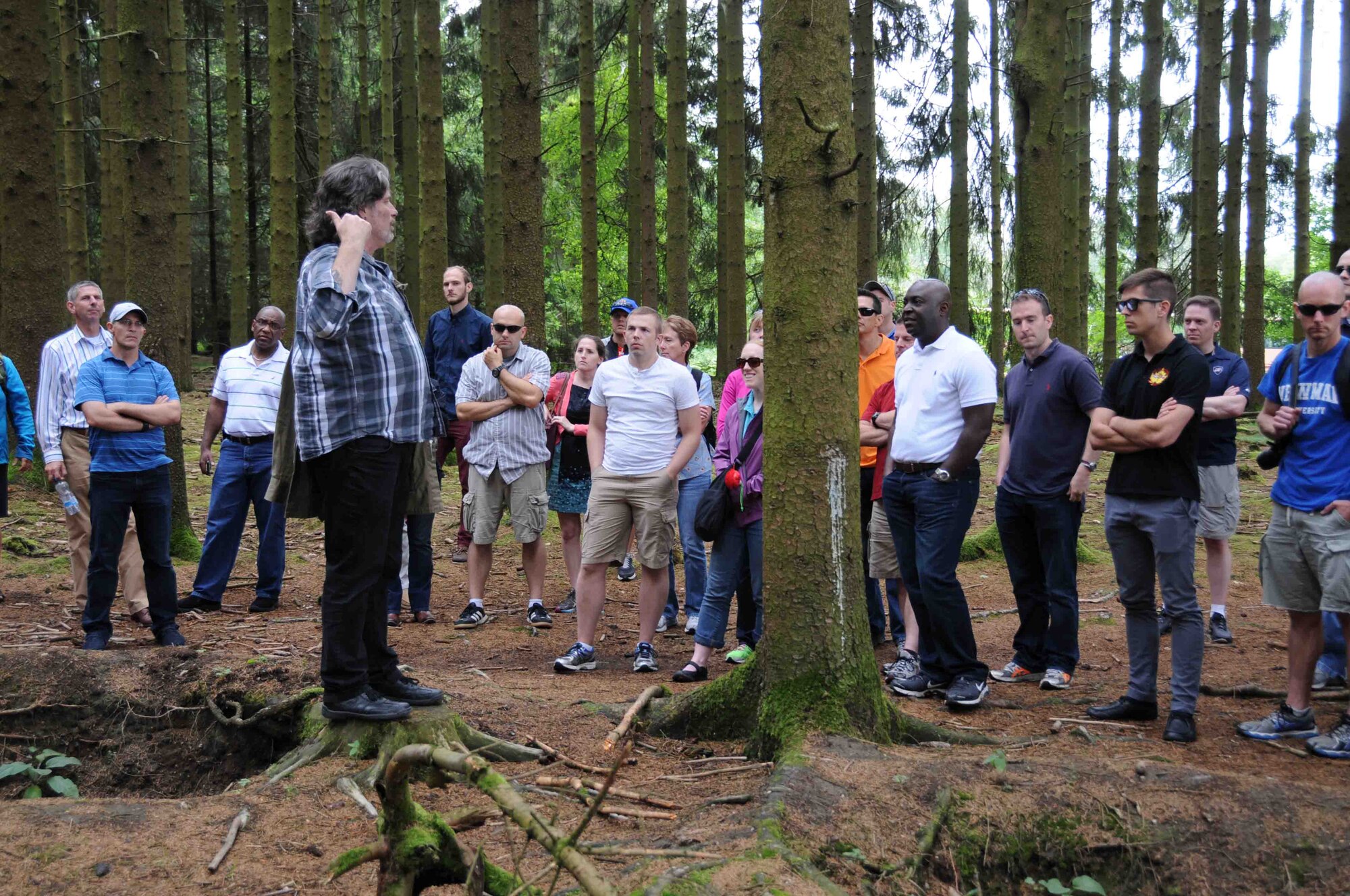 Amongst the foxholes of Easy Company, 2nd Battalion, 506th Parachute Infantry Battalion, USO tour guide Bob Allen explains to a group of international reserve officers the conditions American infantrymen faced during the siege of Bastogne in 1944 during a tour July 19.  Forty-six reserve component officers from seven nations participated in the International Junior Officer Development Seminar hosted by Air Force Reserve Command at Ramstein Air Base, Germany, July 18-25, 2015. (U.S. Air Force photo/Col. Rob Palmer)
