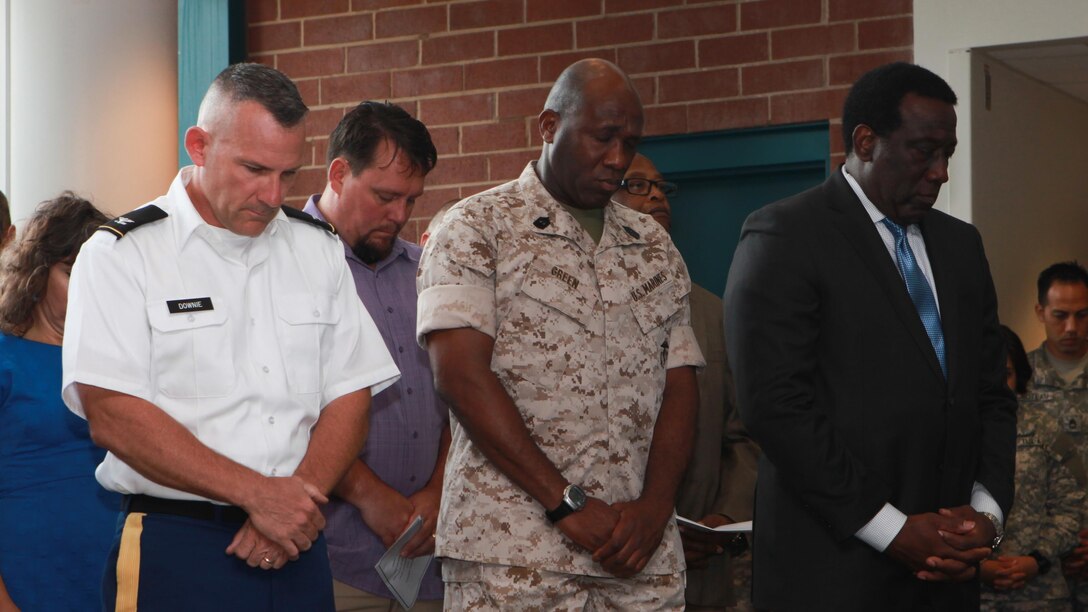 Col. Martin Downie, commandant of the Defense Information School, left, Sgt. Maj. Ronald L. Green, sergeant major of the Marine Corps, middle, and Ray Shepherd, Director of Defense Media Activity, right, bow their heads during a memorial ceremony July 27, 2015, at the Defense Information School, Fort George G. Meade, Md. DINFOS held a ceremony honoring Cpl. Sara Medina and Lance Cpl. Jacob Hug, who lost their lives in a helicopter crash while documenting the relief efforts in Nepal during Operation Sahayogi Haat. 
