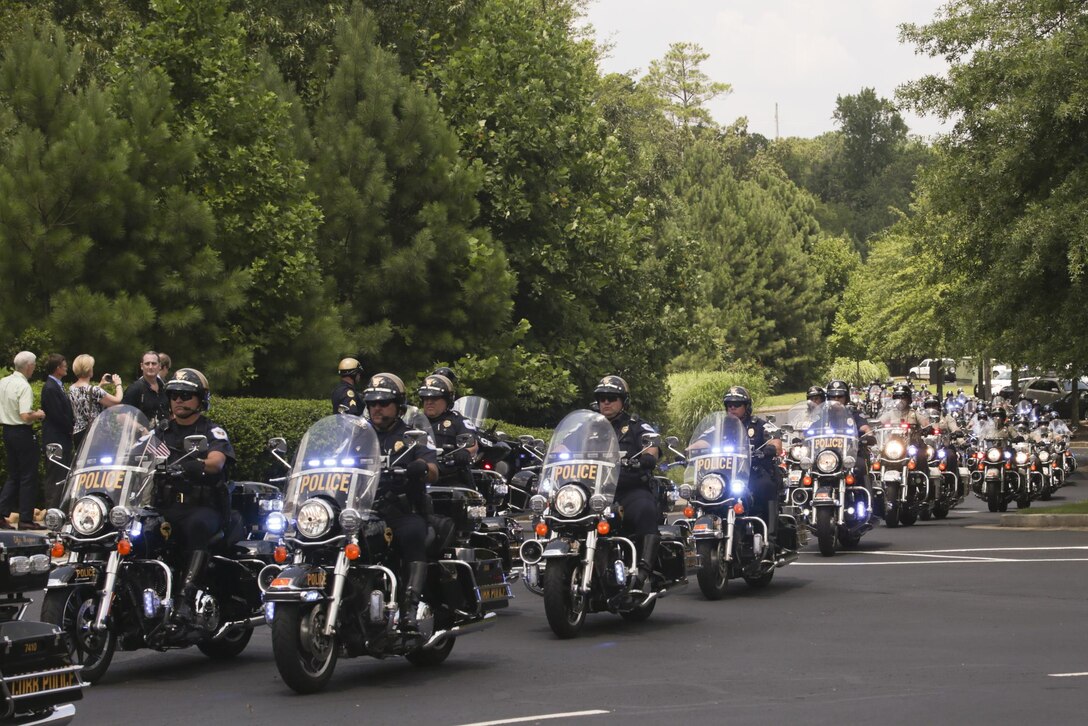 Hundreds of police officers drive cars and motorcycles to escort the hearse of Lance Cpl. Squire “Skip” Wells and his family at the First Baptist Church of Woodstock July 26, 2015. Wells was one of five service members killed during a shooting at the Naval Operational Support Center and Marine Corps Reserve Center on July 16, 2015. Hundreds of people were present at the service showing their respect and support for Wells, his family and friends. (U.S Marine Corps photo by Corporal Ian Ferro)