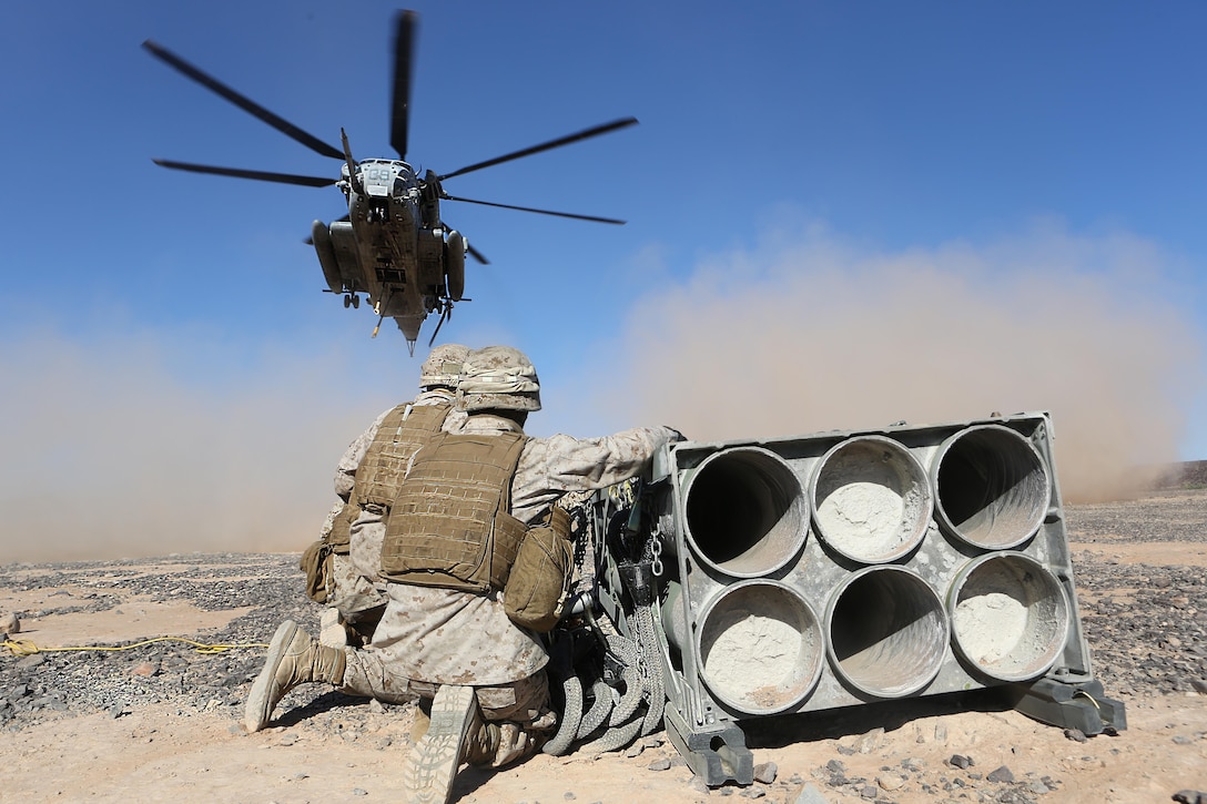 Marines with Combat Logistics Battalion 13 wait as a CH-53E Super Stallion with Marine Heavy Helicopter Squadron 462 prepares to lift a decommissioned rocket pod aboard Marine Corps Air Station Yuma, Ariz., Oct. 23. The training helped the Marines experience the effects of the aircraft while trying to attach the cargo.