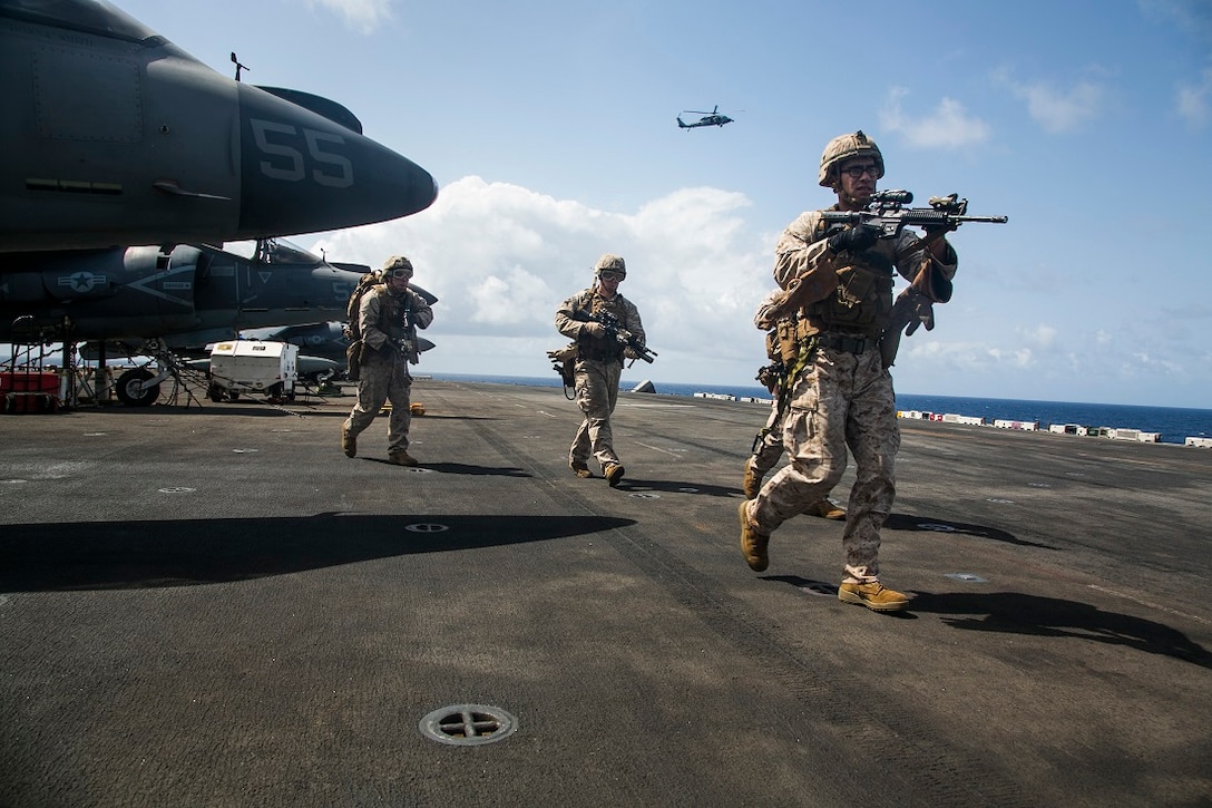 U.S. Marines with the 15th Marine Expeditionary Unit’s Maritime Raid Force practice an initial clear after fast-roping onto the amphibious assault ship USS Essex in the Indian Ocean July, 24. These Marines are assigned to India Company, Battalion Landing Team 3rd Battalion, 1st Marine Regiment, 15th MEU, and are members of the MRF’s security element. The Marines practiced fast-roping onto the flight deck and simulated clearing the ship. Elements of the 15th MEU, based out of Camp Pendleton, California, and embarked aboard the Essex, are conducting naval operations in the 6th Fleet areas of operation in support of U.S. national security interests in Europe and Africa. 
