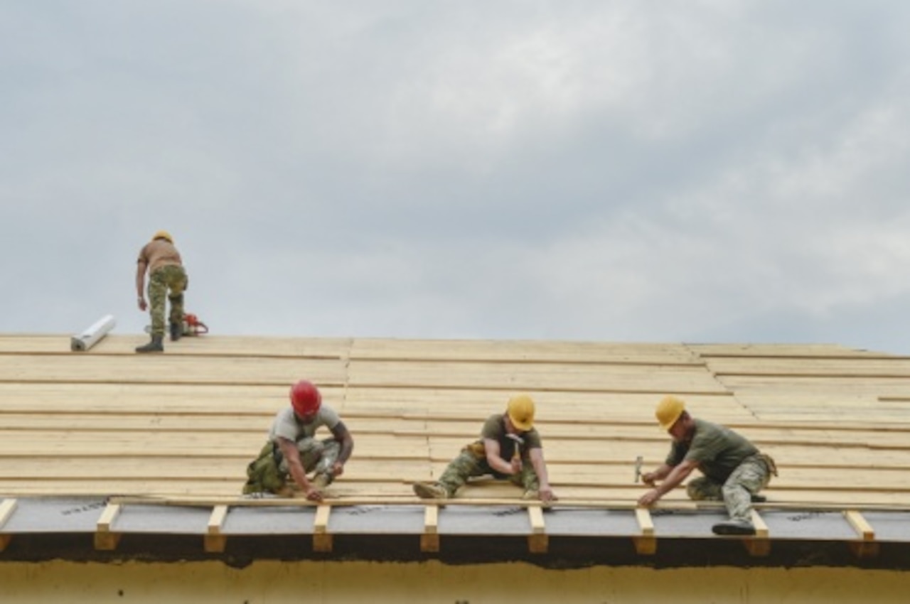 Minnesota National Guard soldiers with the 851st Vertical Engineer Company work together with members of the Croatian army’s Armored Mechanic Brigade to repair and rebuild a roof on a damaged community center in the town of Racinovci, Croatia, June 29, 2015. Minnesota National Guard photo by Air Force Tech Sgt. Lynette Olivares