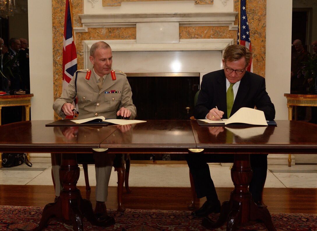 Maj. Gen. John Crackett of the British army, assistant chief of the defense staff for reserves and cadets, and Paul D. Patrick, deputy assistant secretary of defense for reserve readiness, training and mobilization, sign a Military Reserve Exchange Program memorandum between the United Kingdom and the United States during a ceremony at the British ambassador's residence in Washington, July 27, 2015. DoD photo by Steve Turner