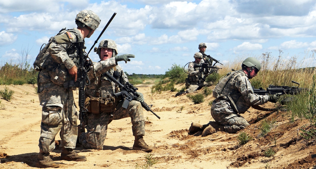 U.S. Army Sgt. Gregory Padilla, second from left, gives a status report to platoon leader U.S. Army 2nd Lt. Randy Jozwiak during a live-fire exercise as part Northern Strike 15 on Camp Grayling Joint Maneuver Training Center, Mich., July 20, 2015. Padilla is a team leader and Jozwiak is a platoon leader assigned to the 1st Battalion, 126th Cavalry Regiment.